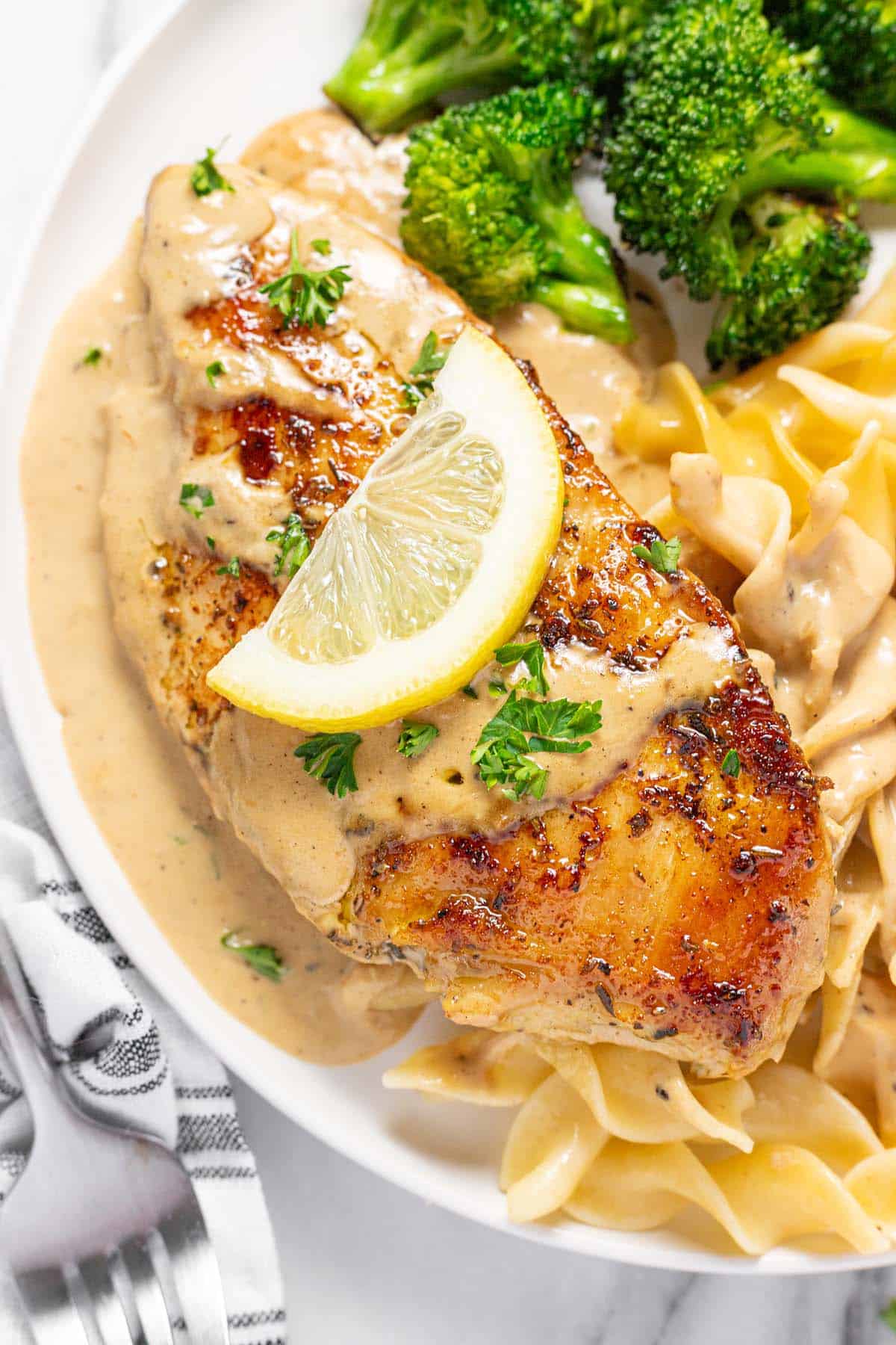 Sauteed chicken breast with lemon cream sauce, pasta, and broccoli. 