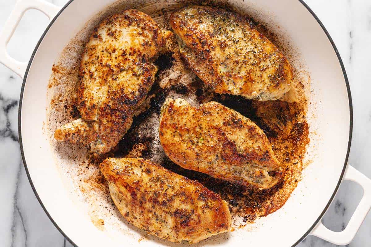 Sauteed chicken breast in a large pan. 