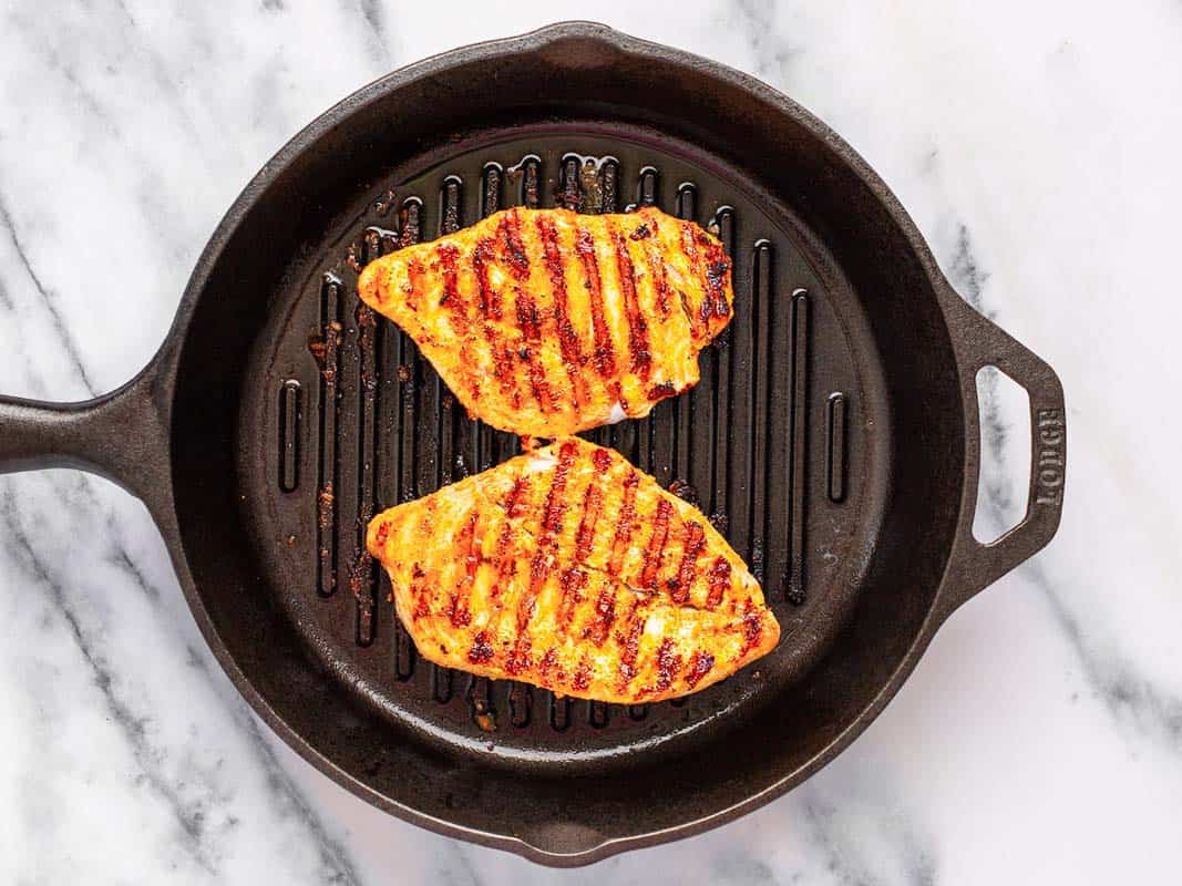 Grilled chicken in a round cast iron grill pan. 