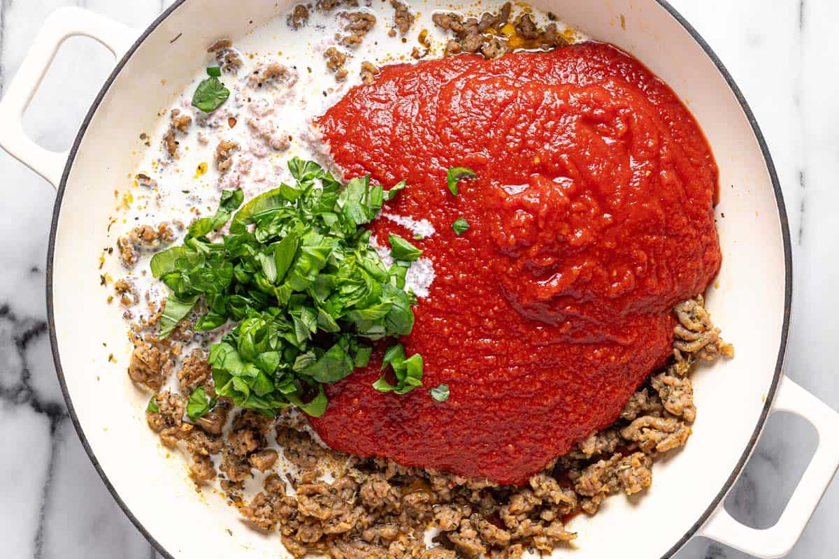Italian sausage, crushed tomatoes, heavy cream, and fresh basil in a large pan. 