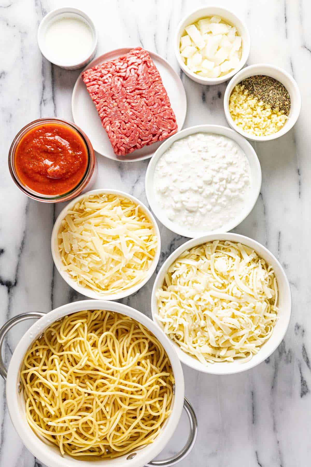 Bowls of ingredients to make homemade spaghetti pie. 