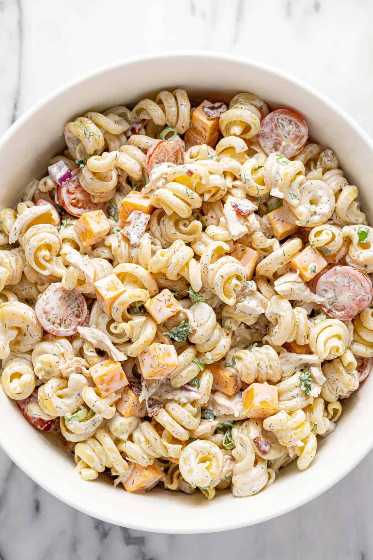 Freshly tossed chicken ranch pasta salad in a large bowl. 