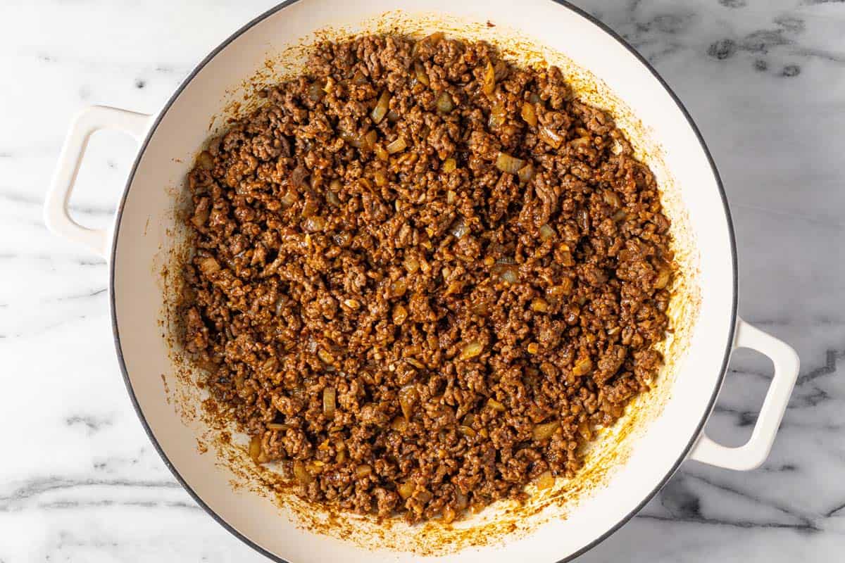 Large saute pan filled with sauteed ground beef seasoned with spices.