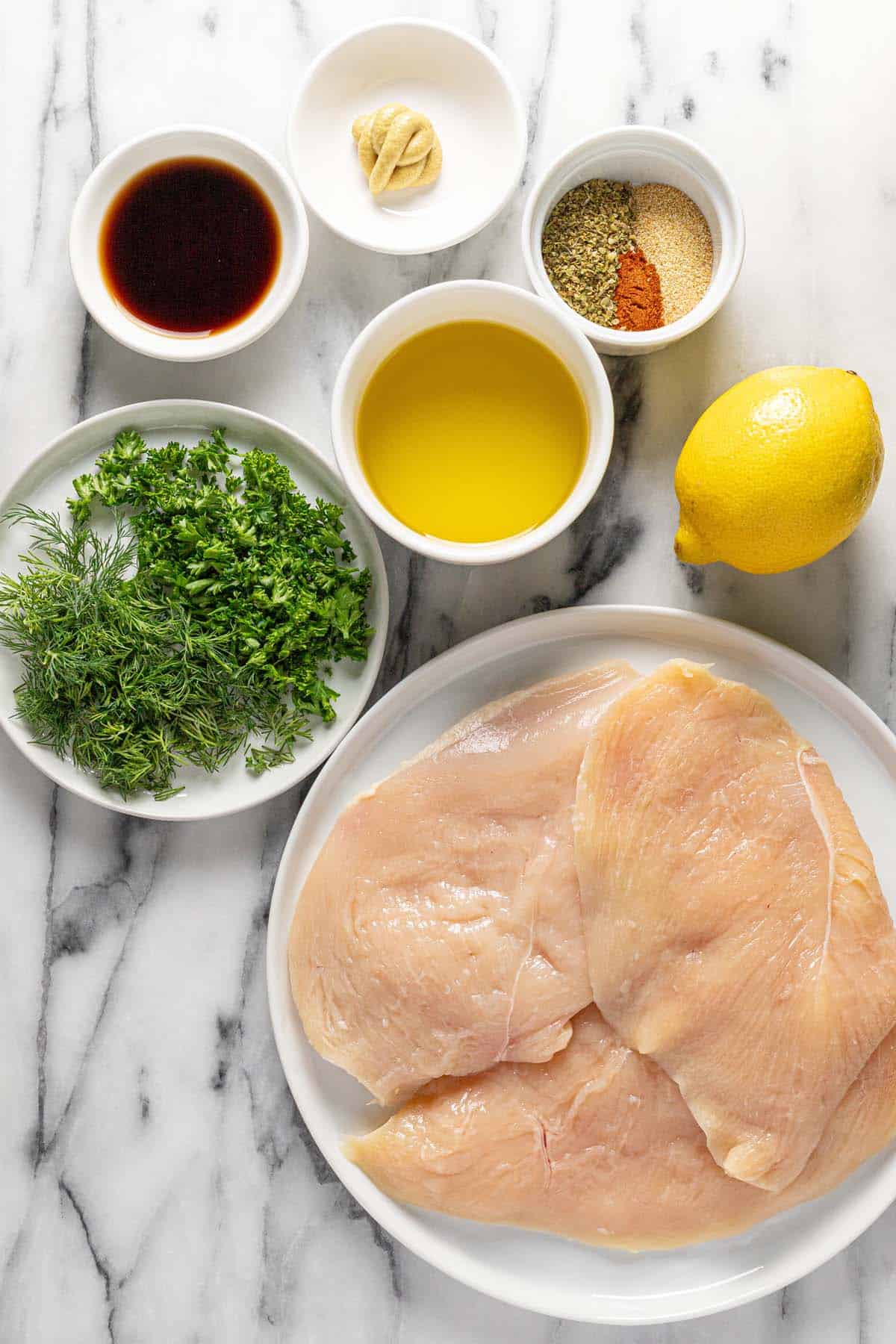 Bowls of ingredients to make Greek chicken. 