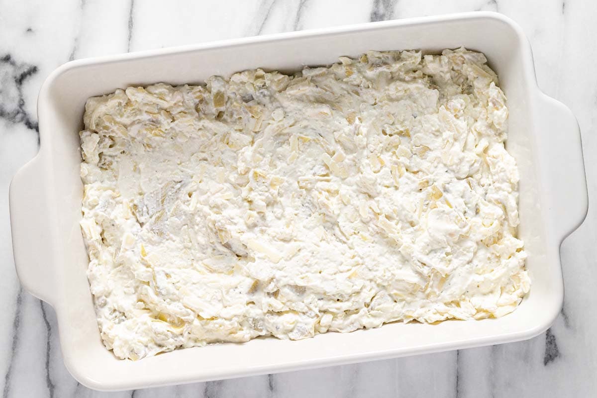 Baking dish with creamy feta dip spread in an even layer. 