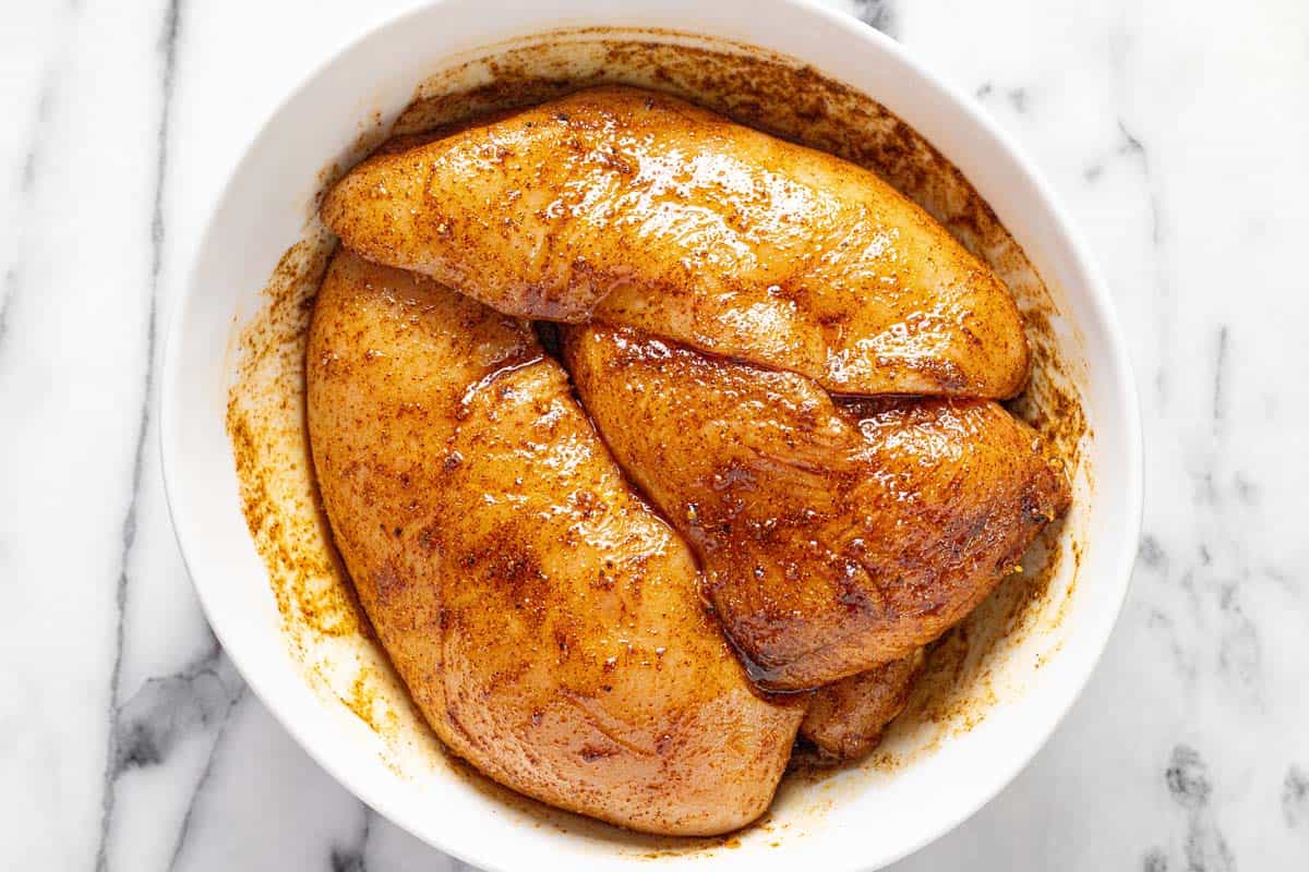 Bowl of marinated chicken breast. 