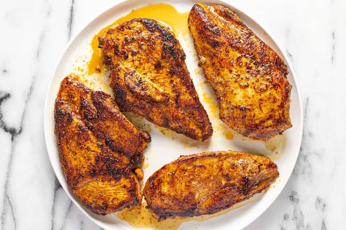 Sauteed chicken breasts on a white plate. 