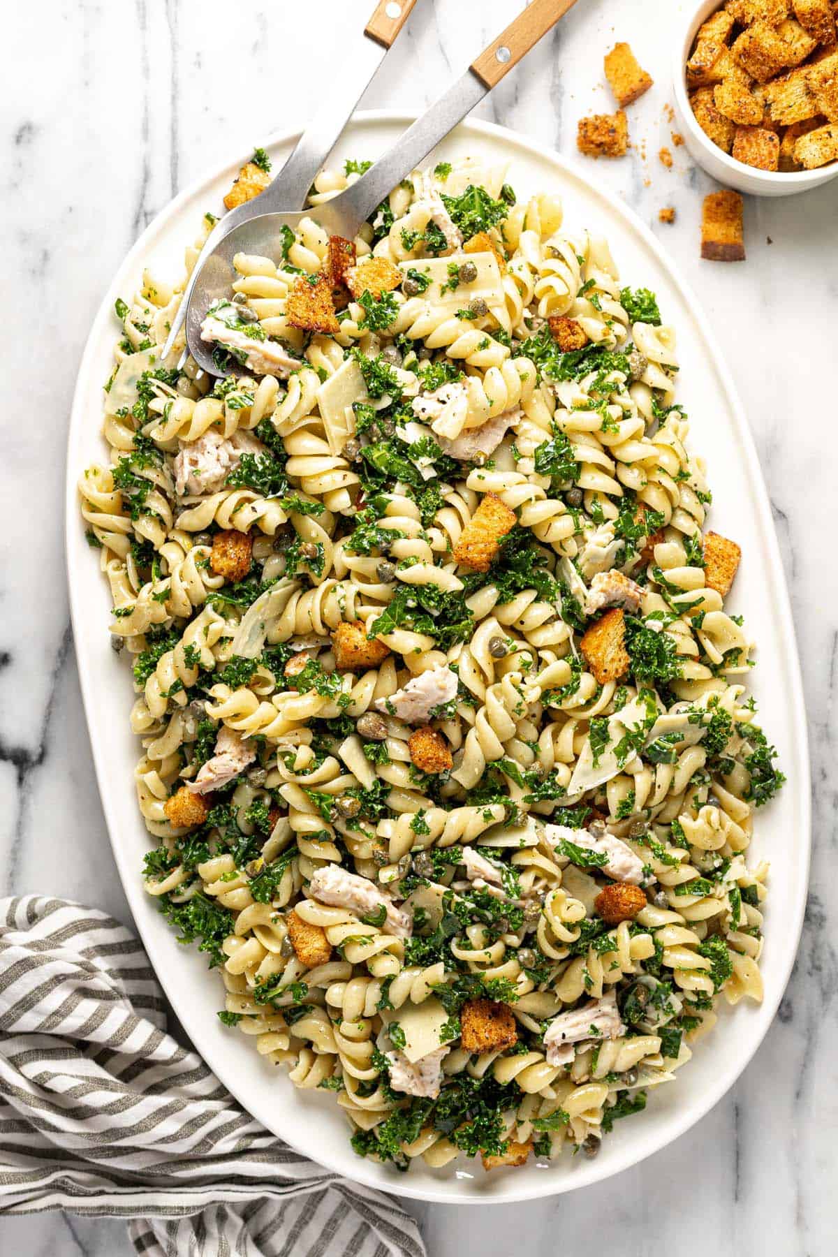 Large platter filled with chicken Caesar pasta salad. 