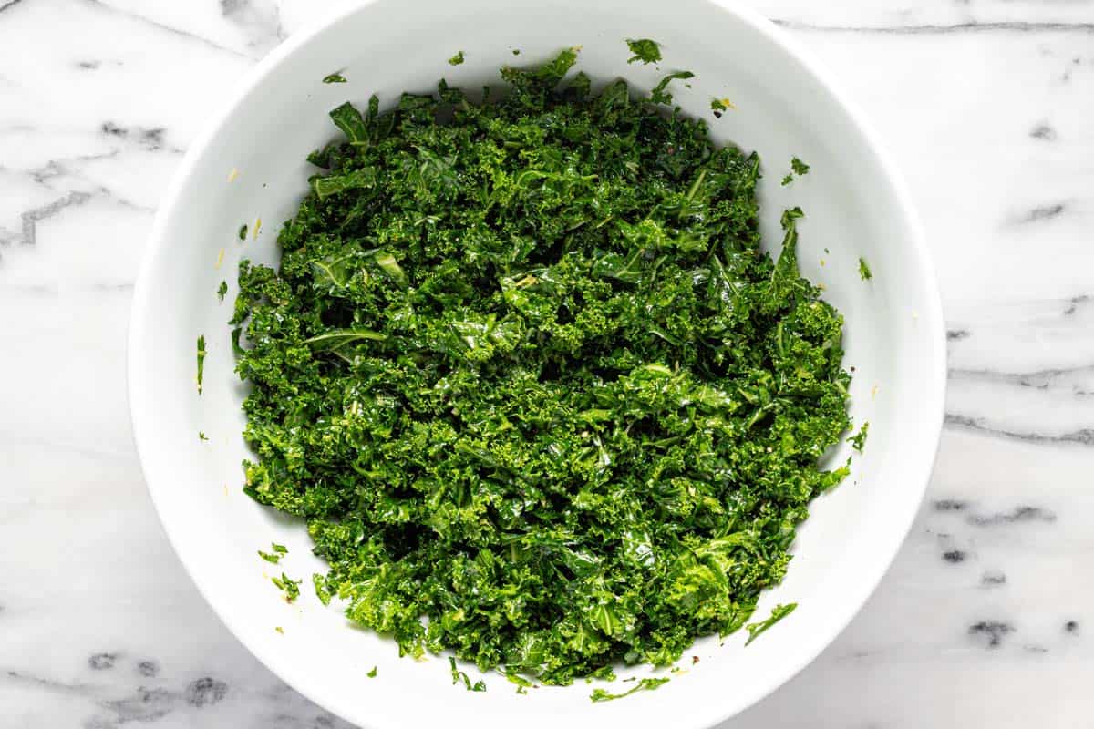 Large bowl filled with massaged kale. 