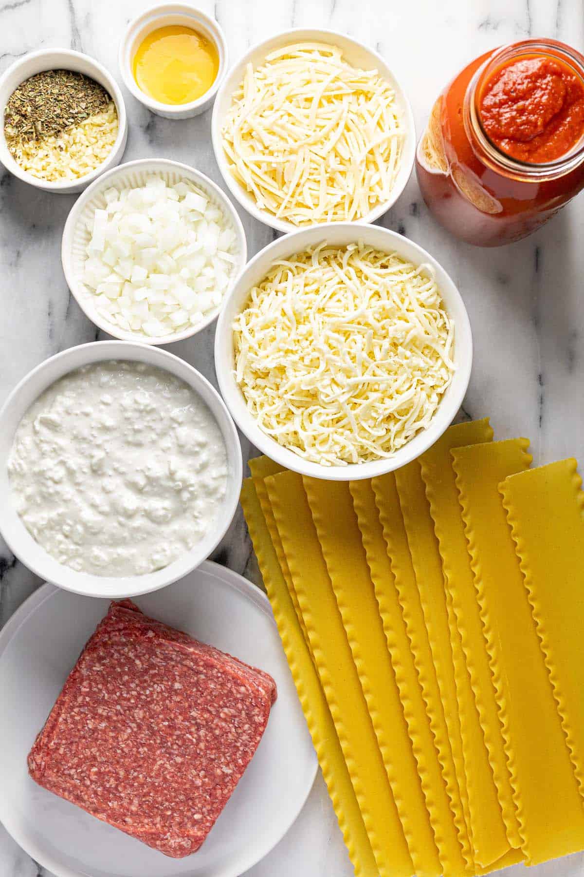 Bowls of ingredients to make slow cooker lasagna. 