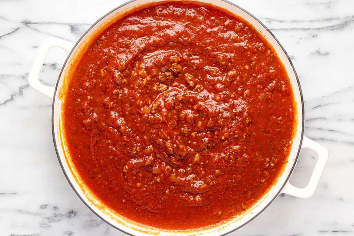 Large sauté pan filled with meat sauce for lasagna. 