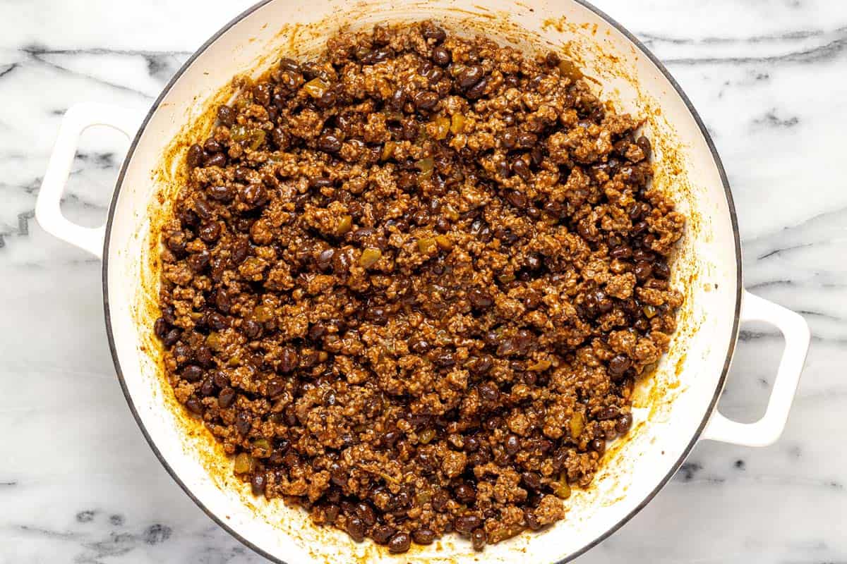 Large pan filled with ground beef enchilada filling. 