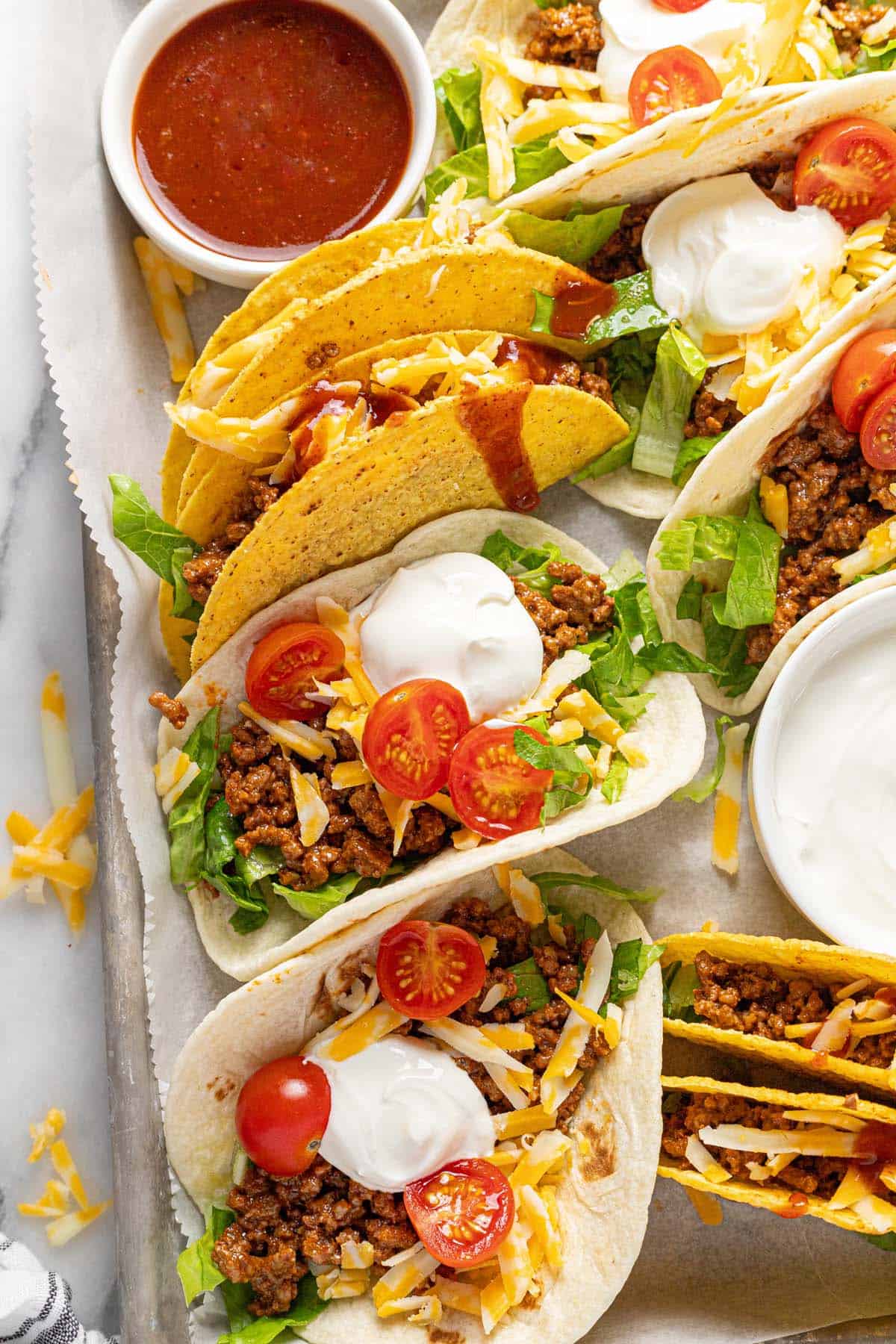 Close up shot of soft and crispy tacos on a baking sheet. 