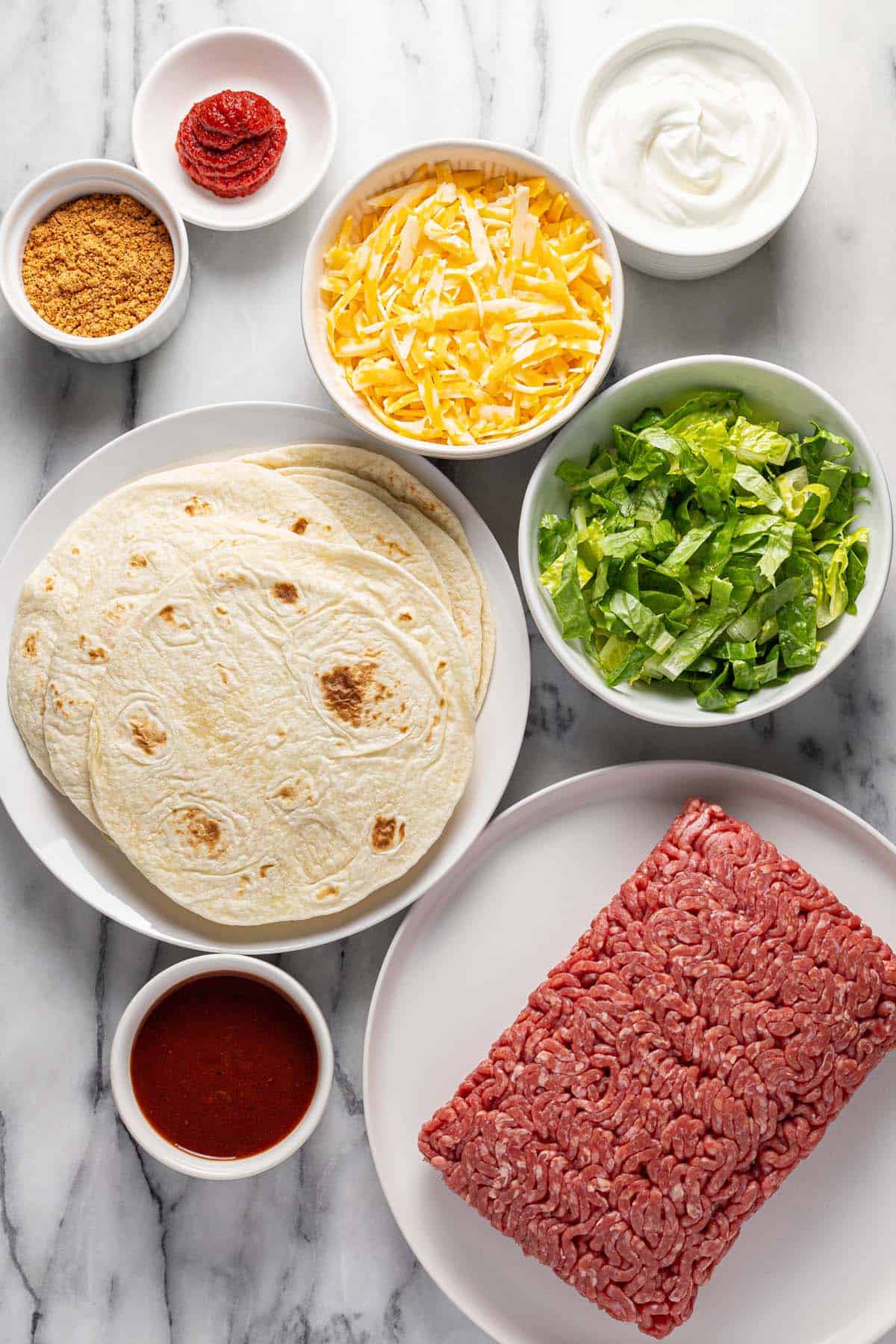 Bowls of ingredients to make homemade ground beef tacos. 