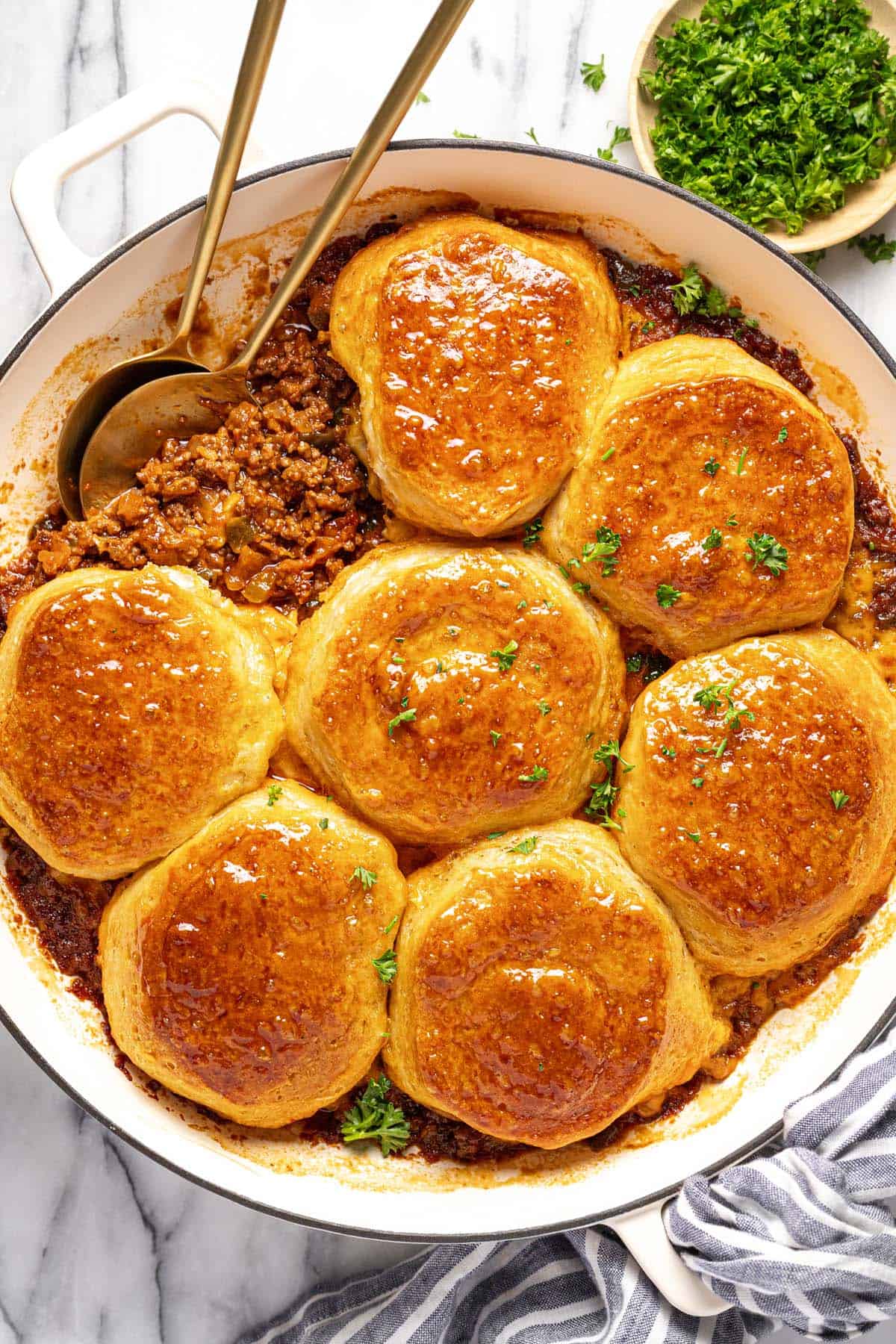 Large pan filled with homemade sloppy joe casserole topped with baked biscuits. 