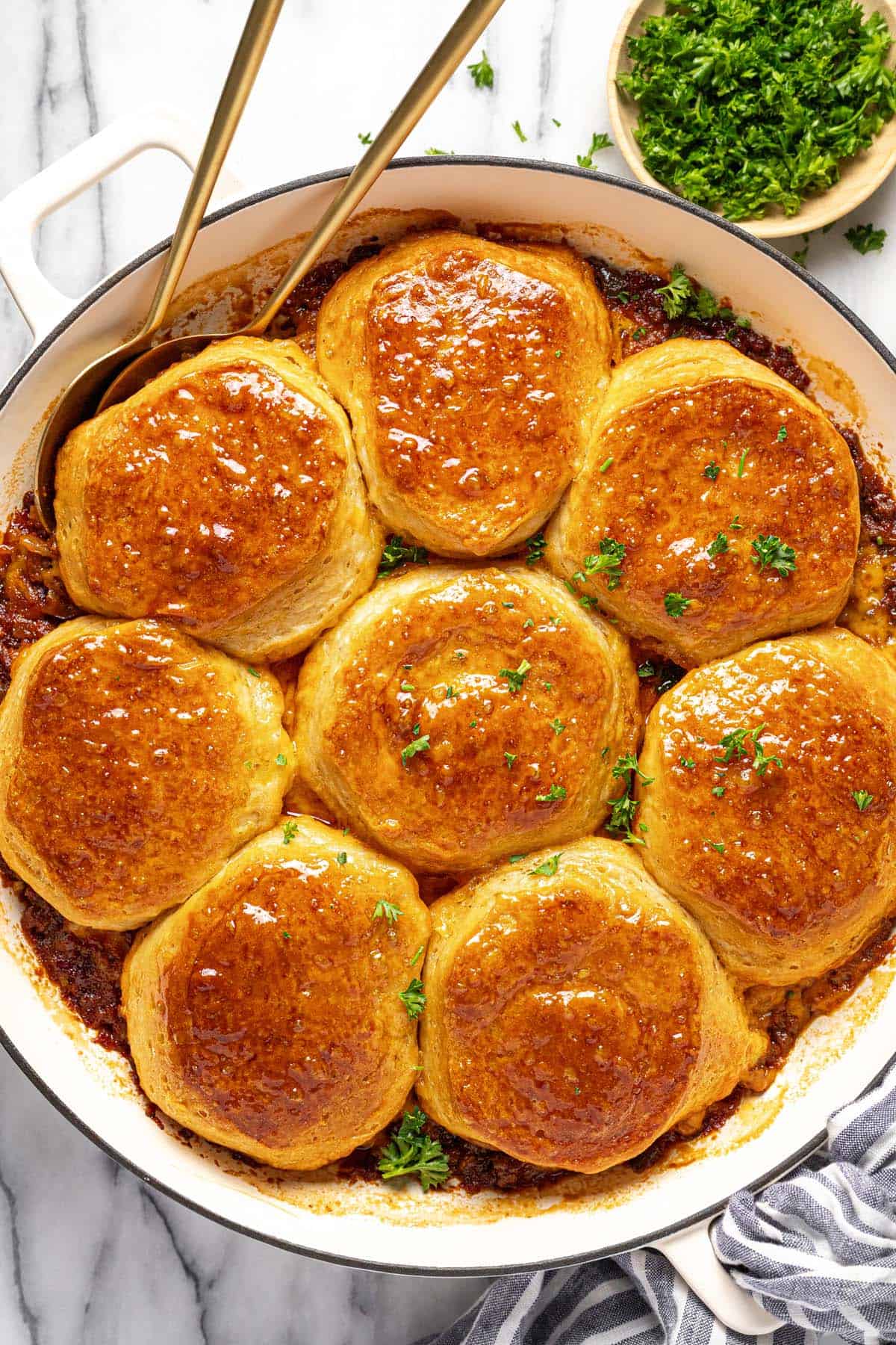 Large pan filled with homemade sloppy joe casserole topped with baked biscuits. 