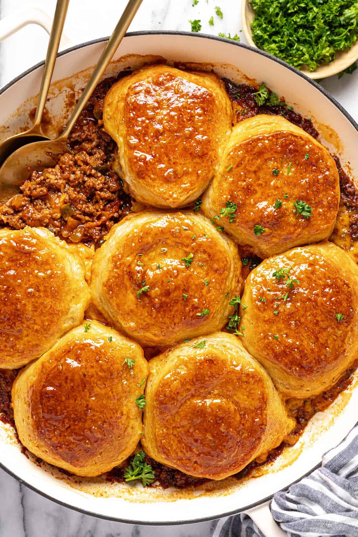 Large pan filled with homemade sloppy joe casserole topped with baked biscuits. 