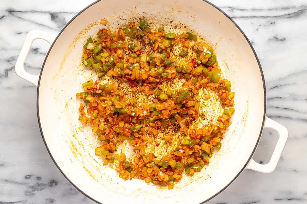 Large pan with sauteed veggies and tomato paste. 