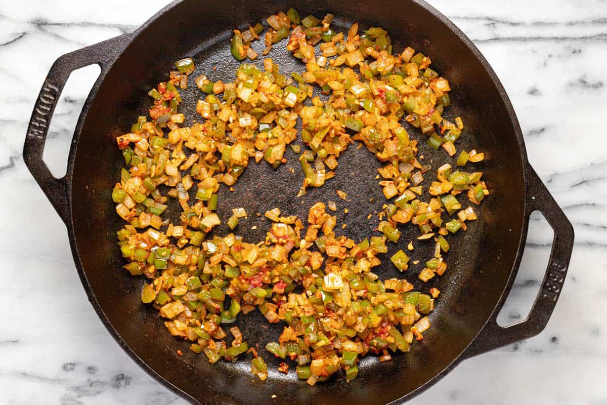 Cast iron skillet with sauteed onion, garlic, and tomato paste. 