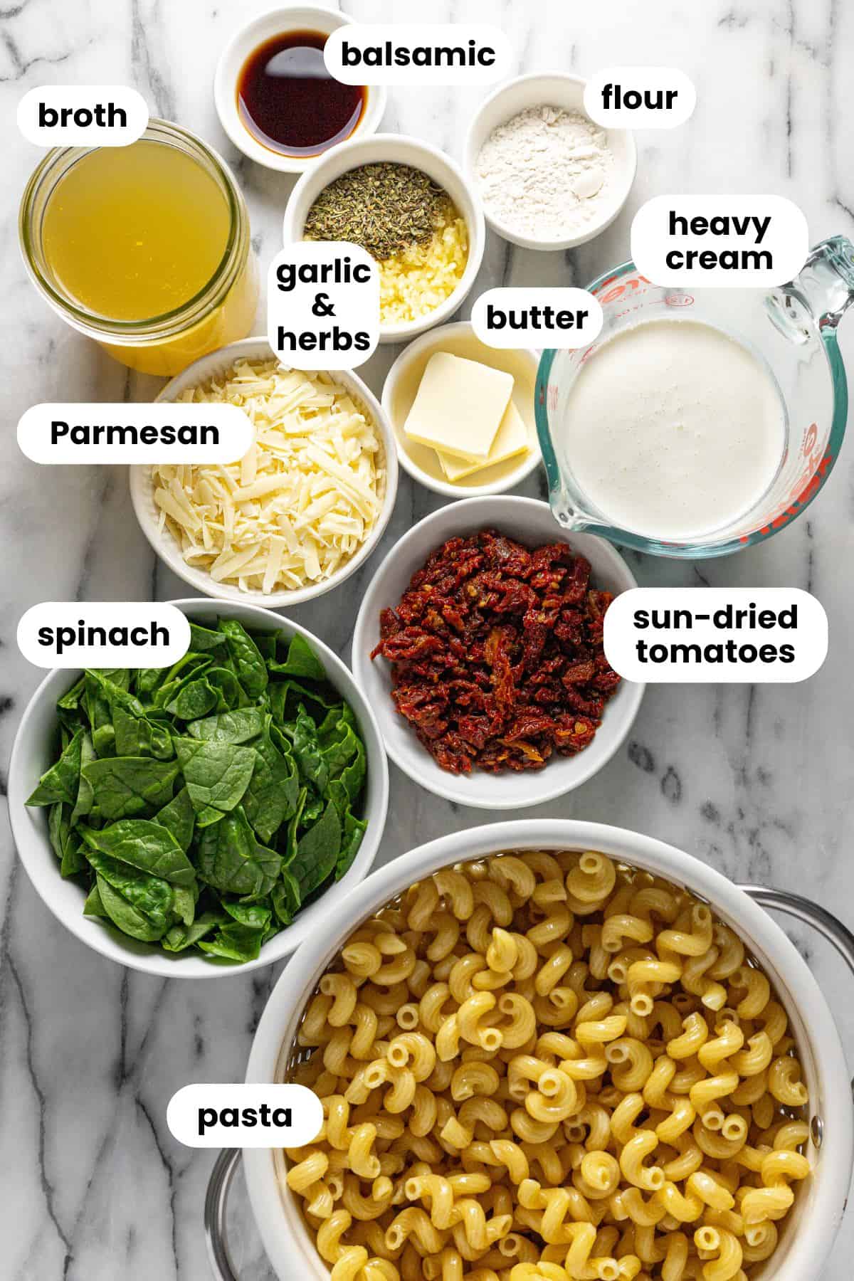 Bowls of ingredients to make sun-dried tomato pasta. 