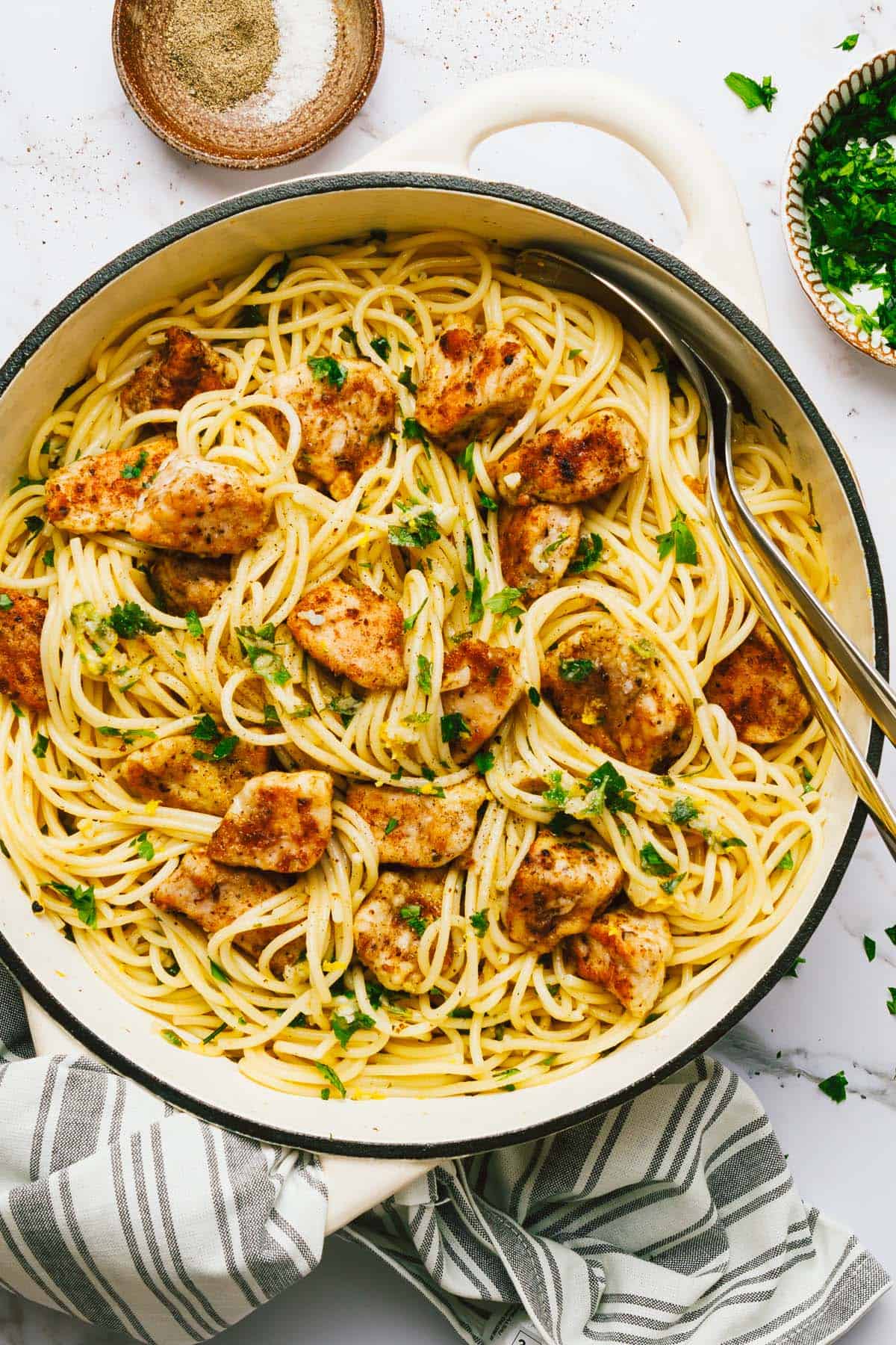 Large pot filled with chicken scampi garnished with fresh parsley. 