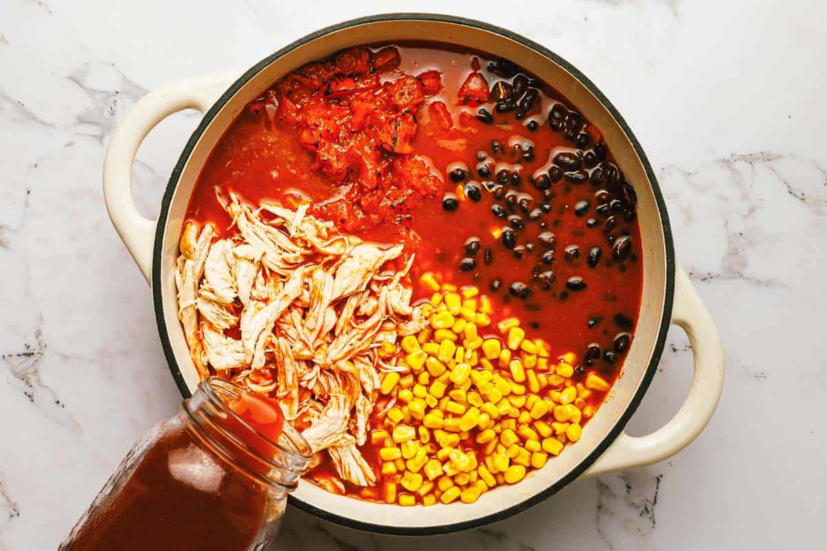 Large pot filled with ingredients to make chicken taco soup. 