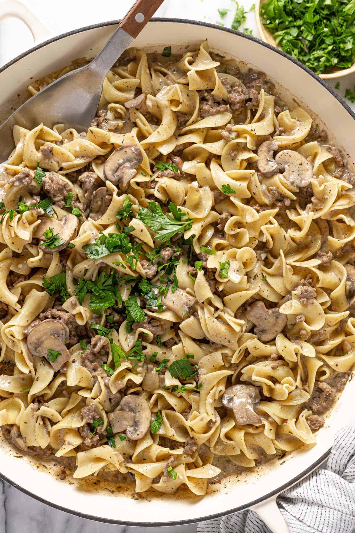 Ground beef stroganoff with egg noodles garnished with fresh parsley. 