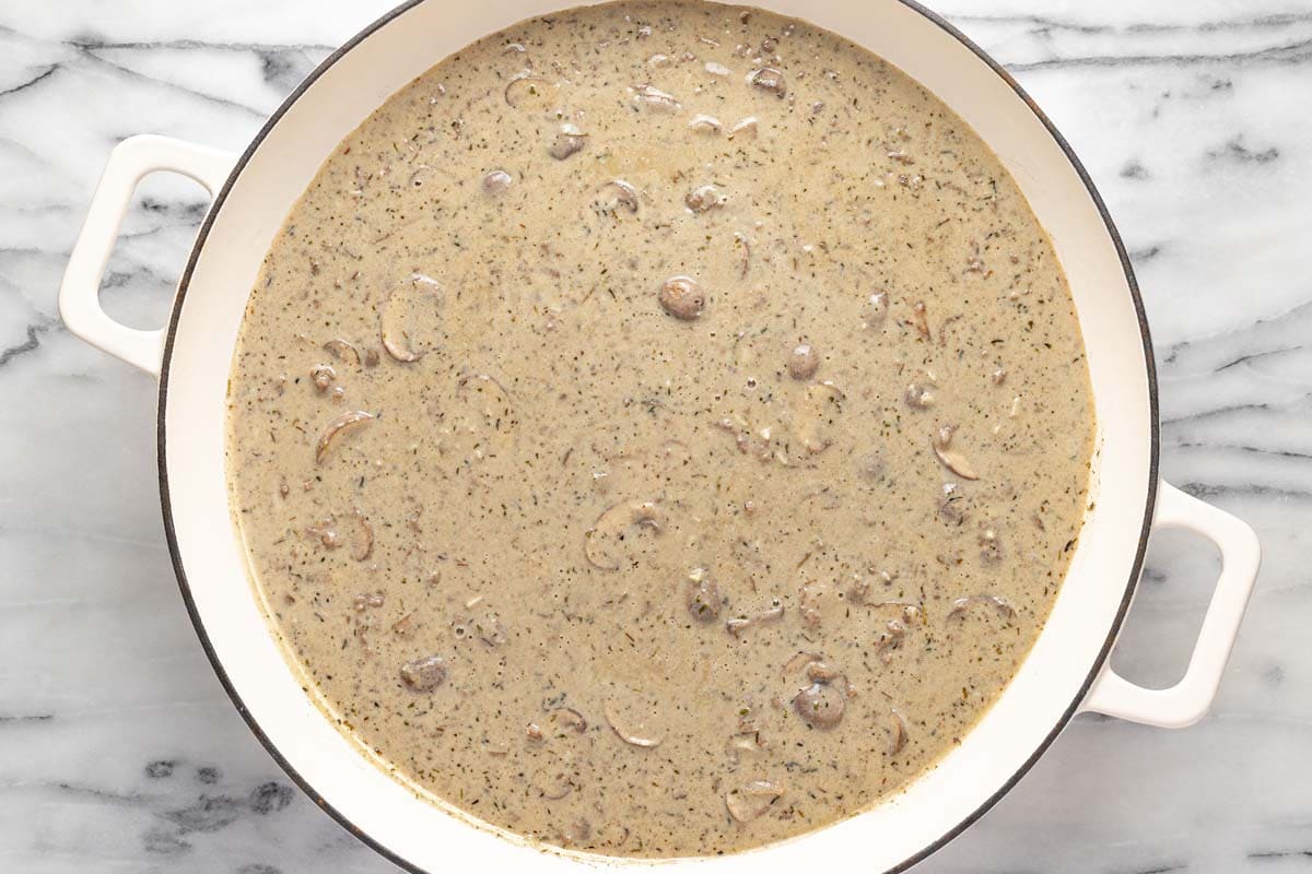 Creamy beef stroganoff sauce in a large pan. 