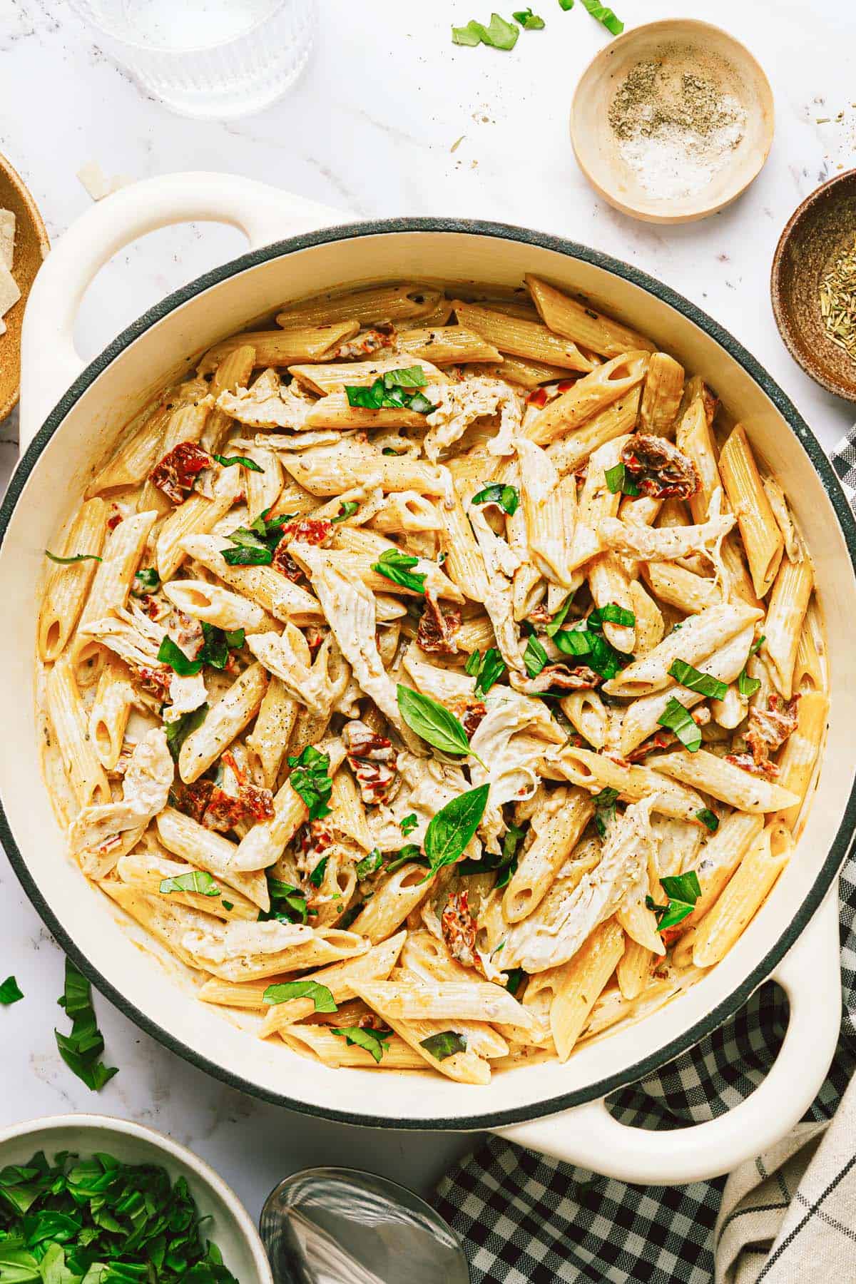 Large pot filled with creamy marry me pasta with chicken garnished with basil. 