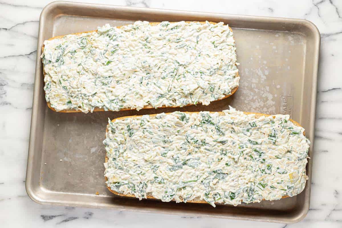 Baking sheet with spinach and artichoke bread on it. 