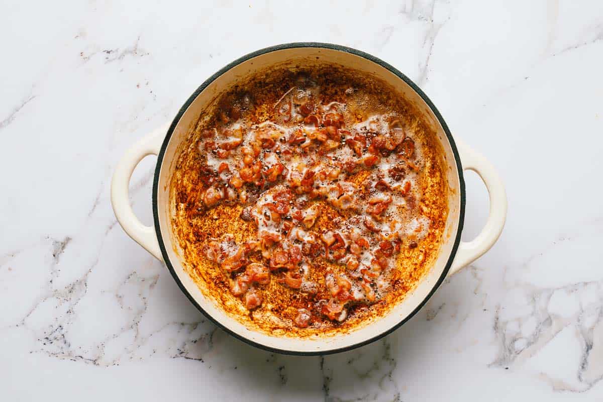 Large pot filled with sauteed bacon. 