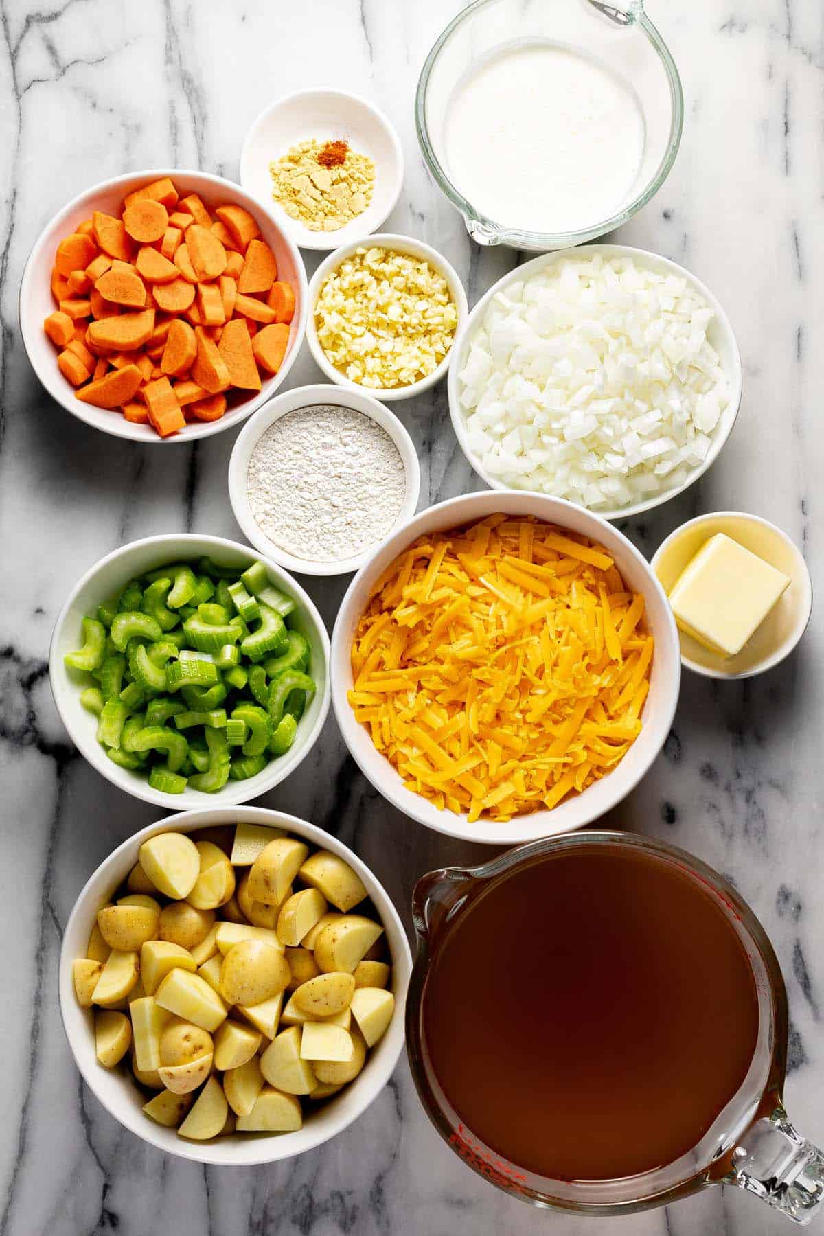 Bowls of ingredients to make cheesy potato soup. 