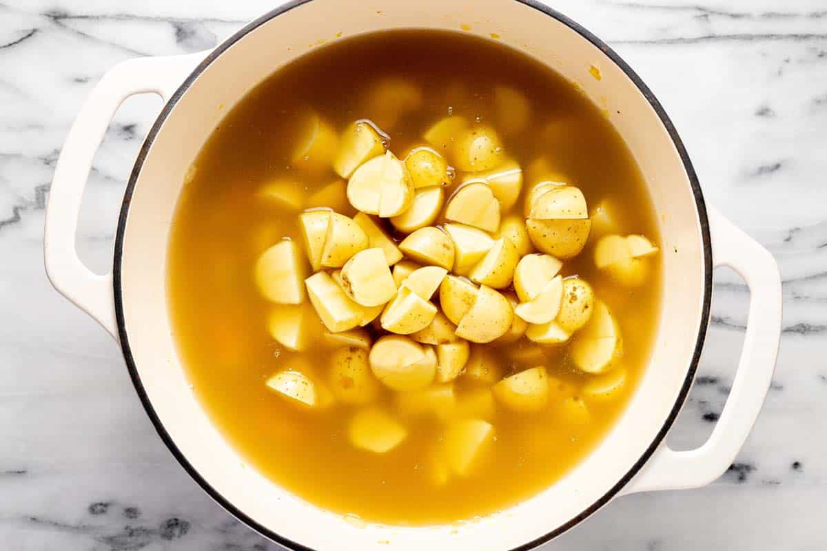 Ingredients to make cheesy potato soup in a large pot. 