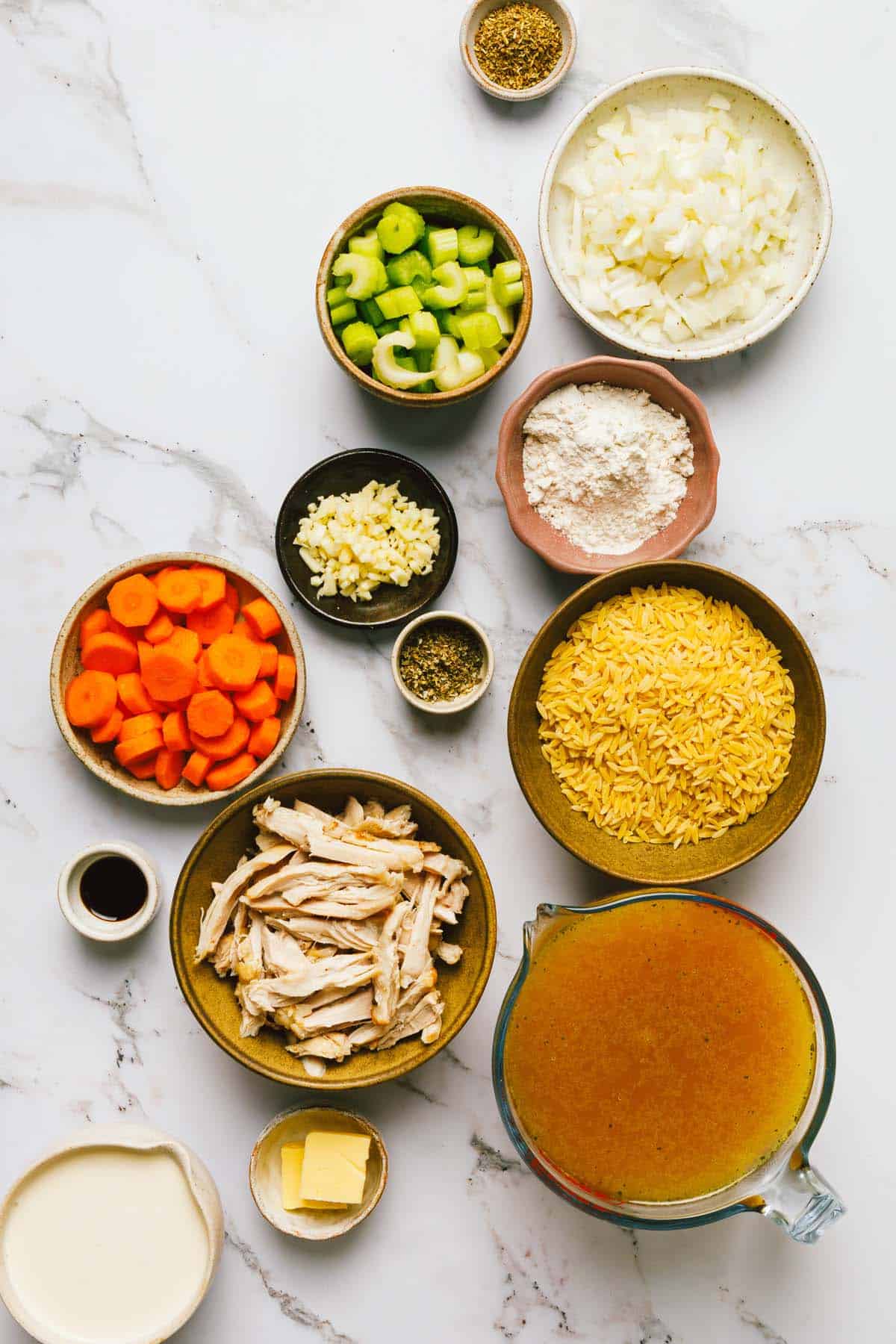 Bowls of ingredients to make creamy chicken orzo soup.