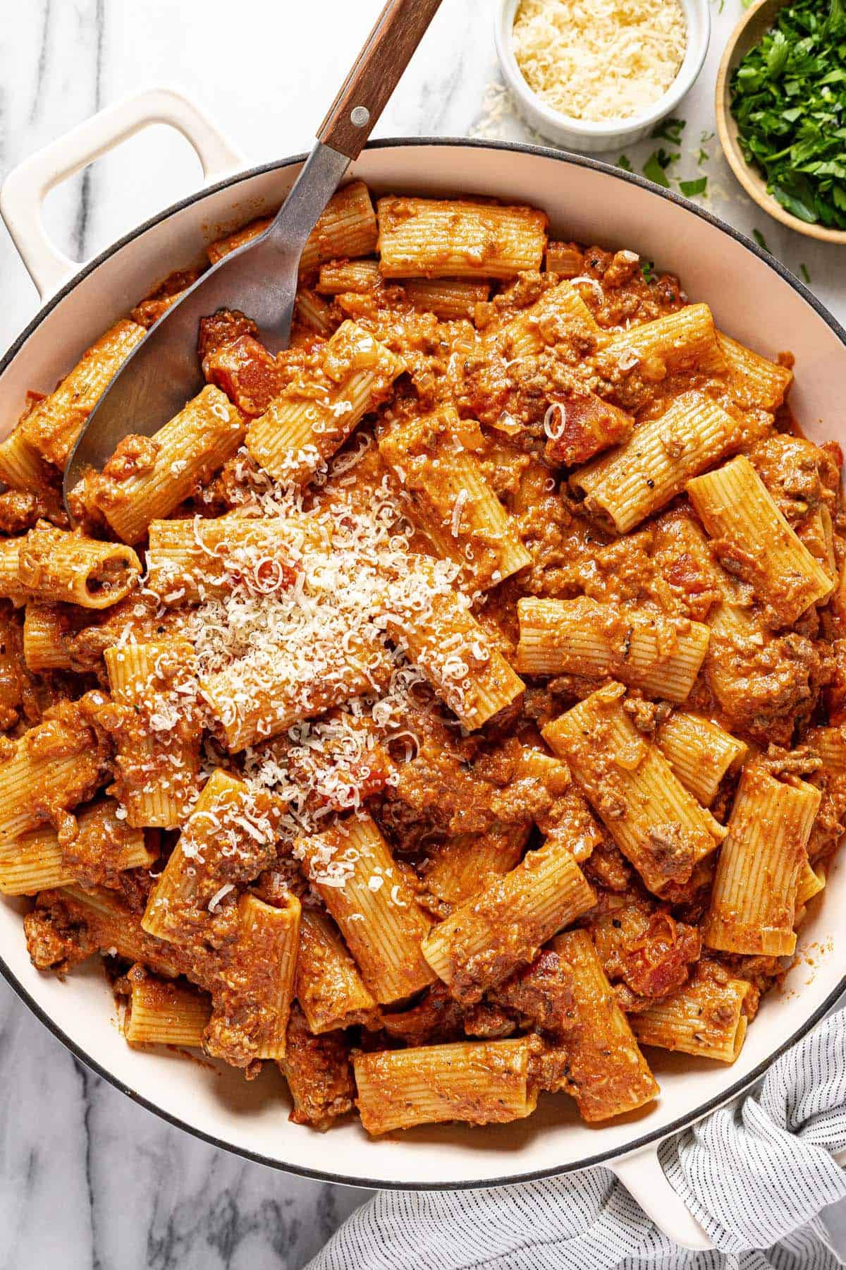 Large pan of ground beef pasta garnished with Parmesan.