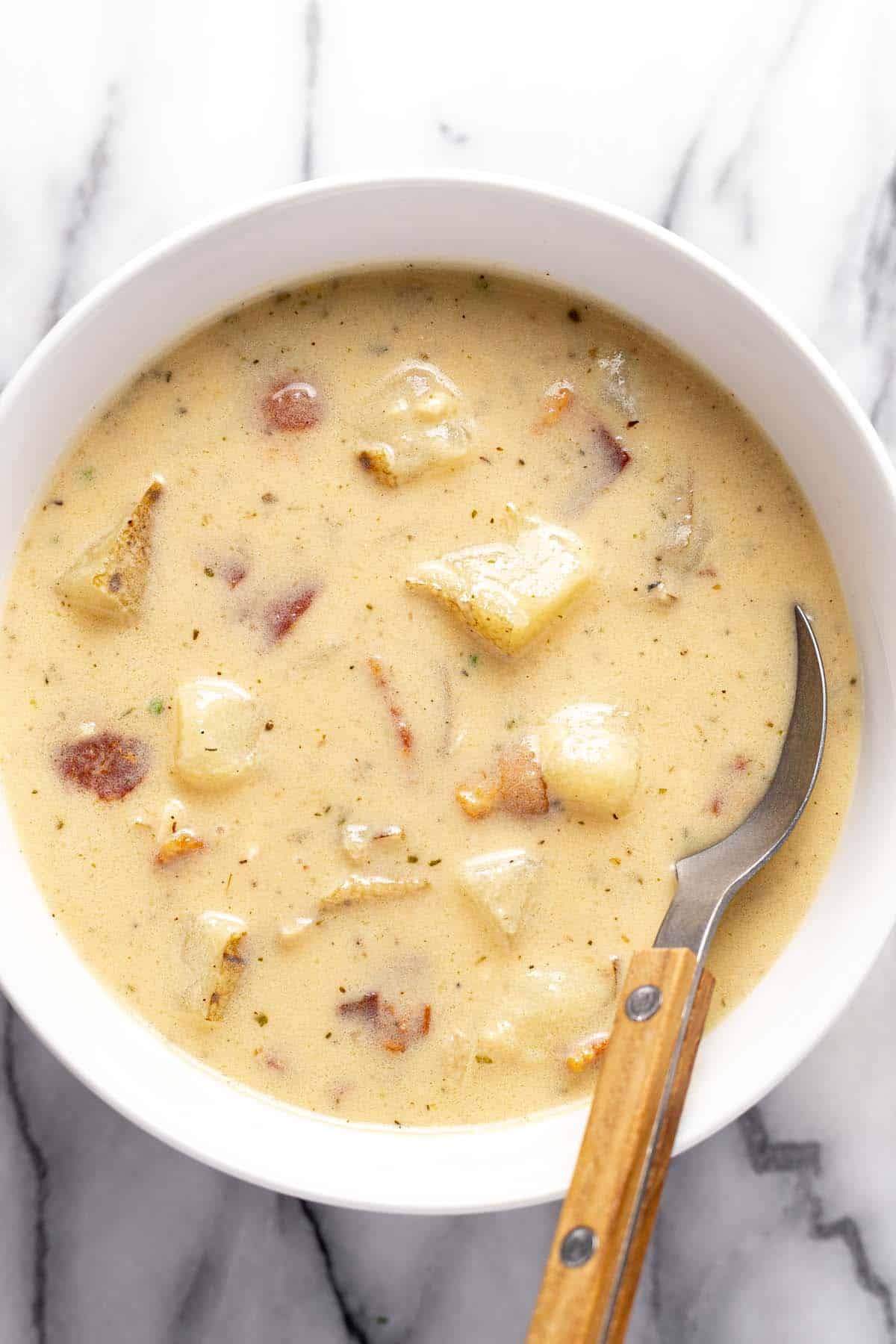 Bowl of loaded baked potato soup with a spoon in it. 