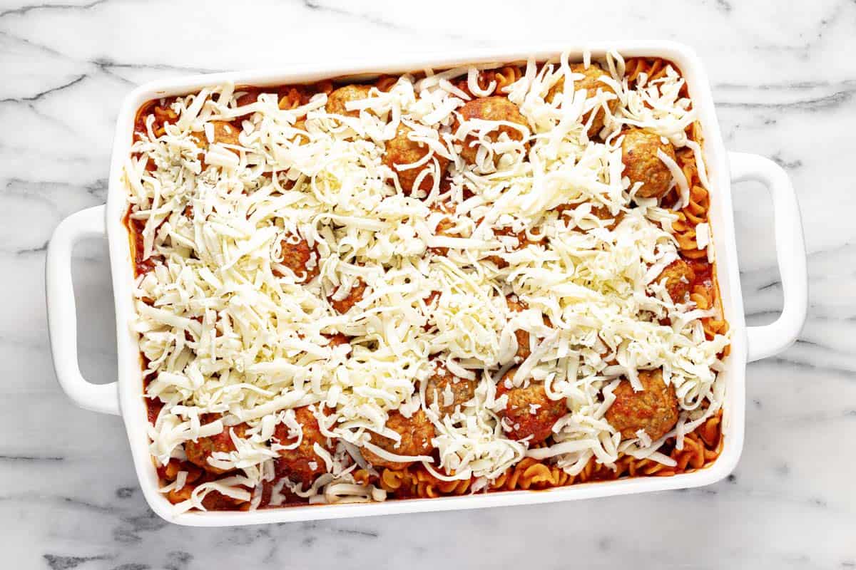 Shredded mozzarella cheese on top of meatball casserole. 