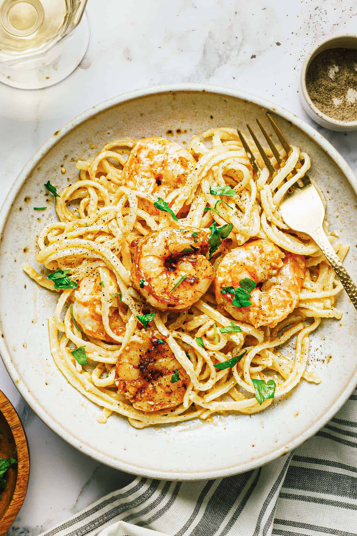 Small plate with shrimp alfredo garnished with parsley. 