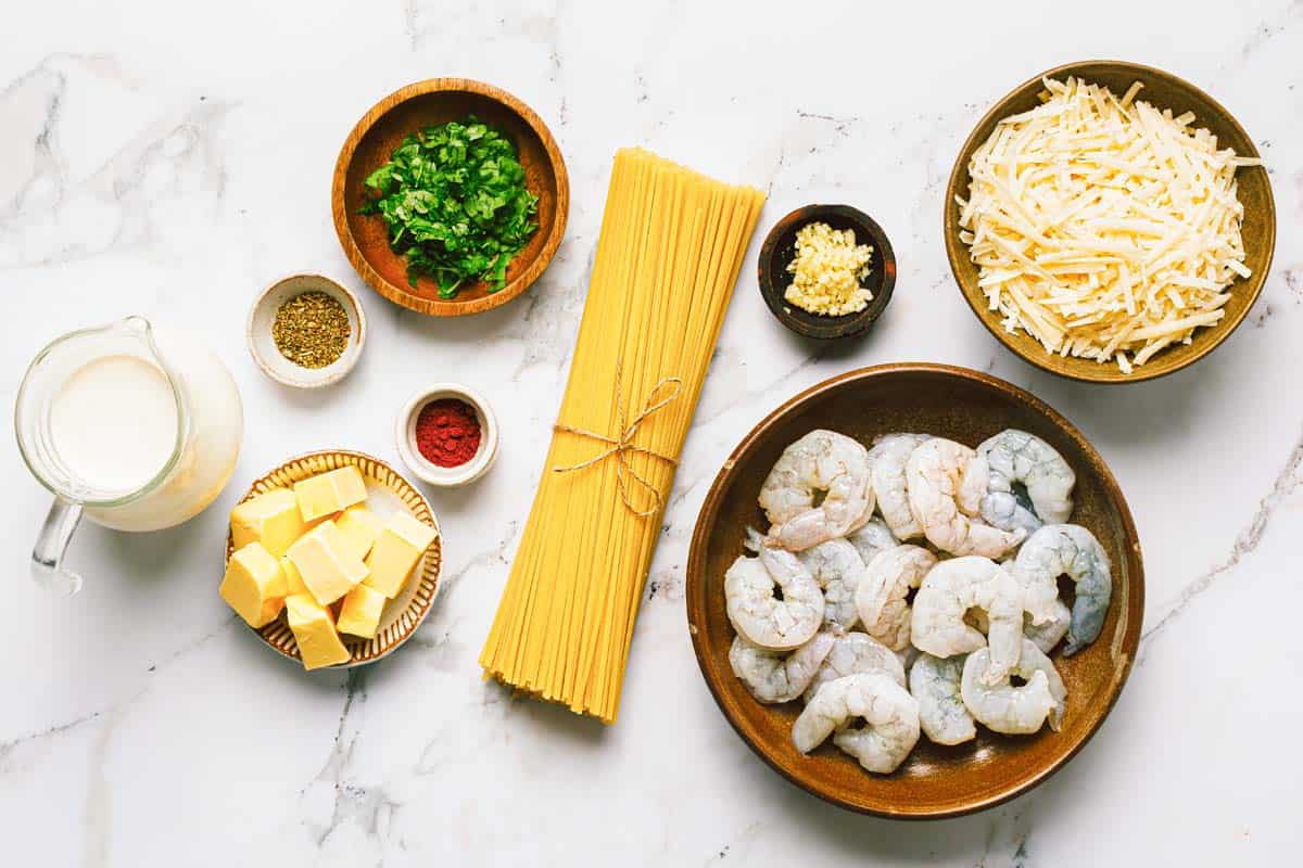 Bowls of ingredients to make shrimp alfredo. 