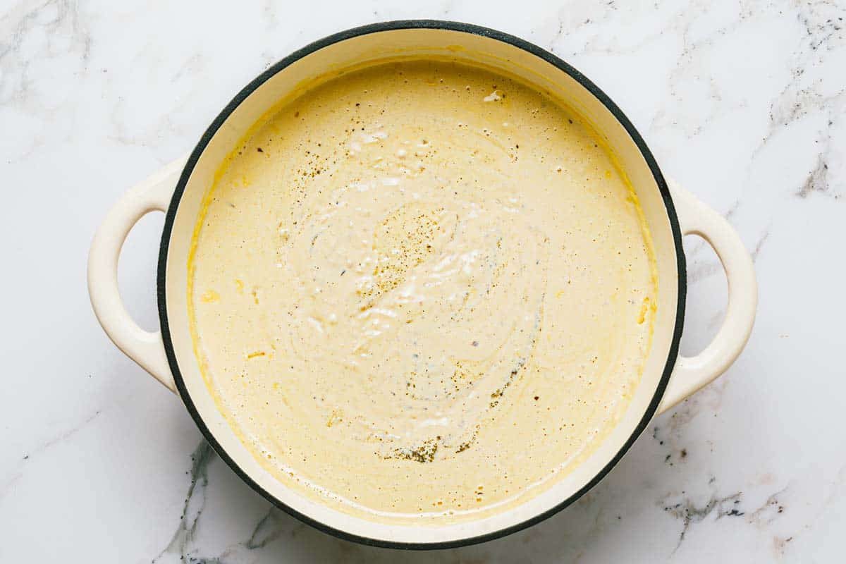 Creamy alfredo sauce in a large pan. 