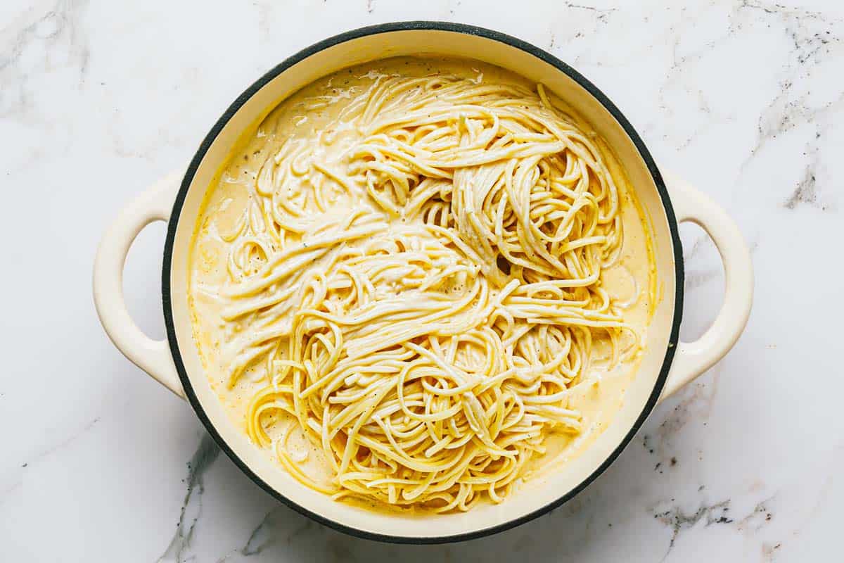 Linguine in alfredo sauce in a large pan. 