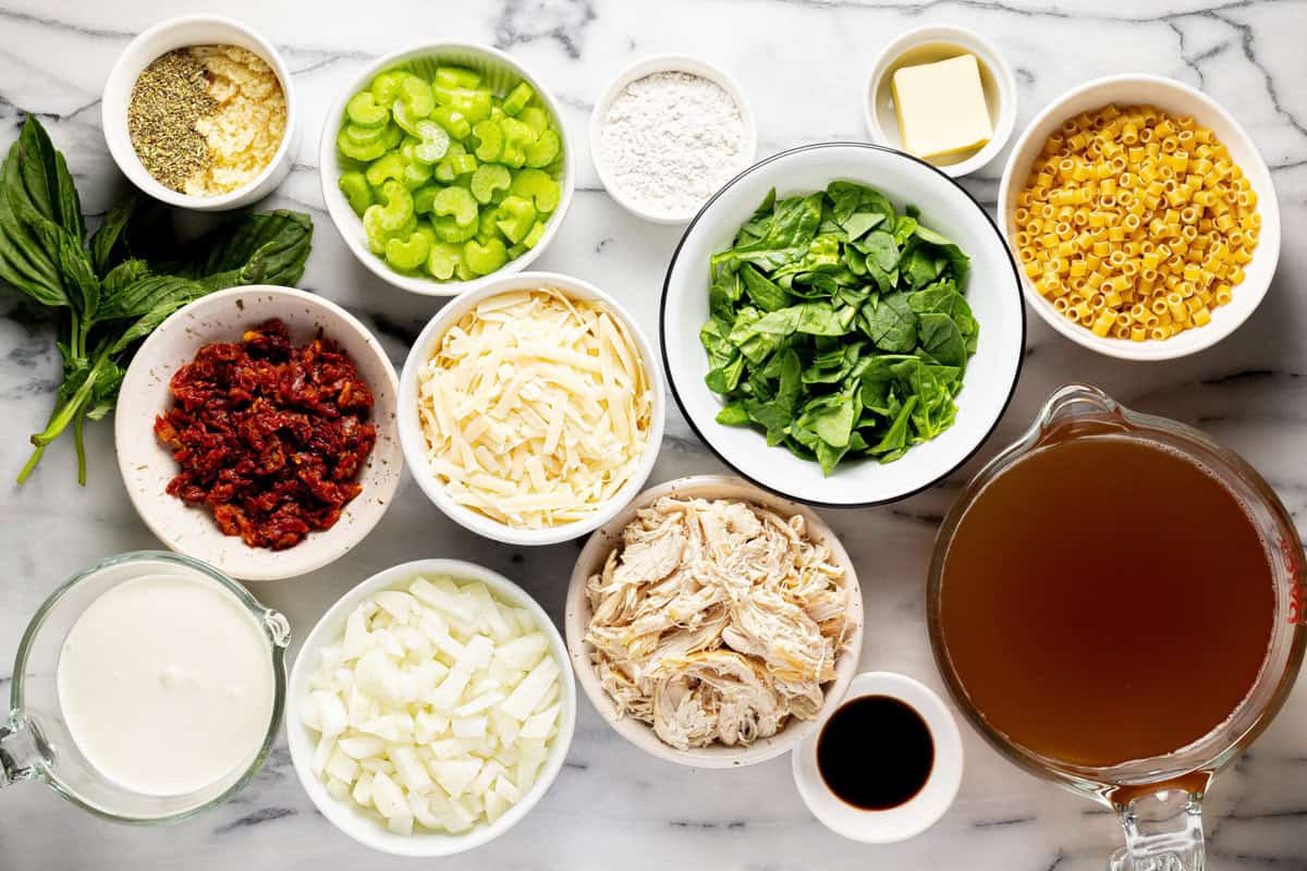 Bowls of ingredients to make Tuscan chicken noodle soup. 