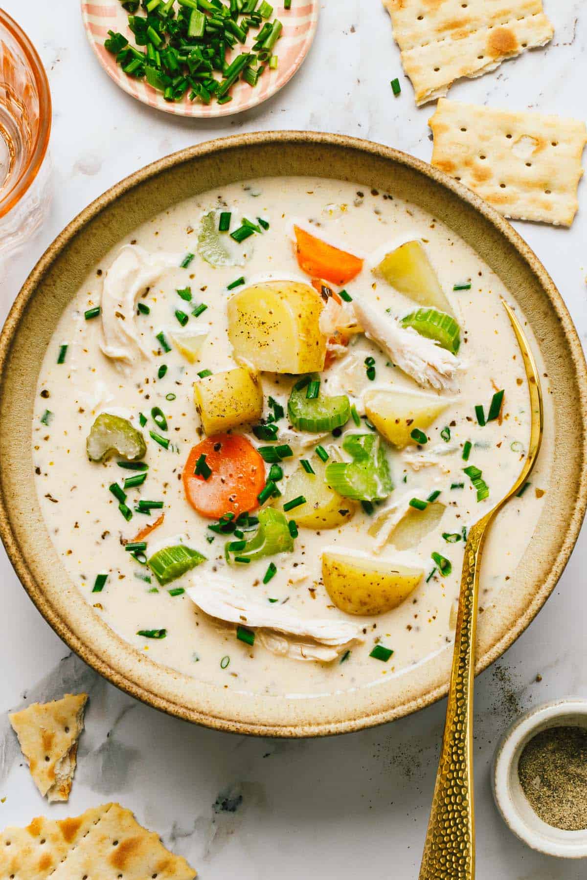 Bowl of chicken potato soup in a bowl garnished with chives. 