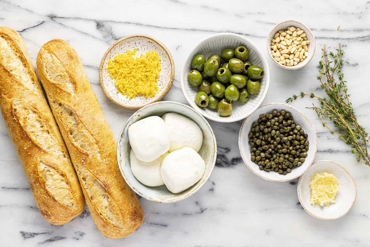 Bowls of ingredients to make burrata cheese appetizer. 