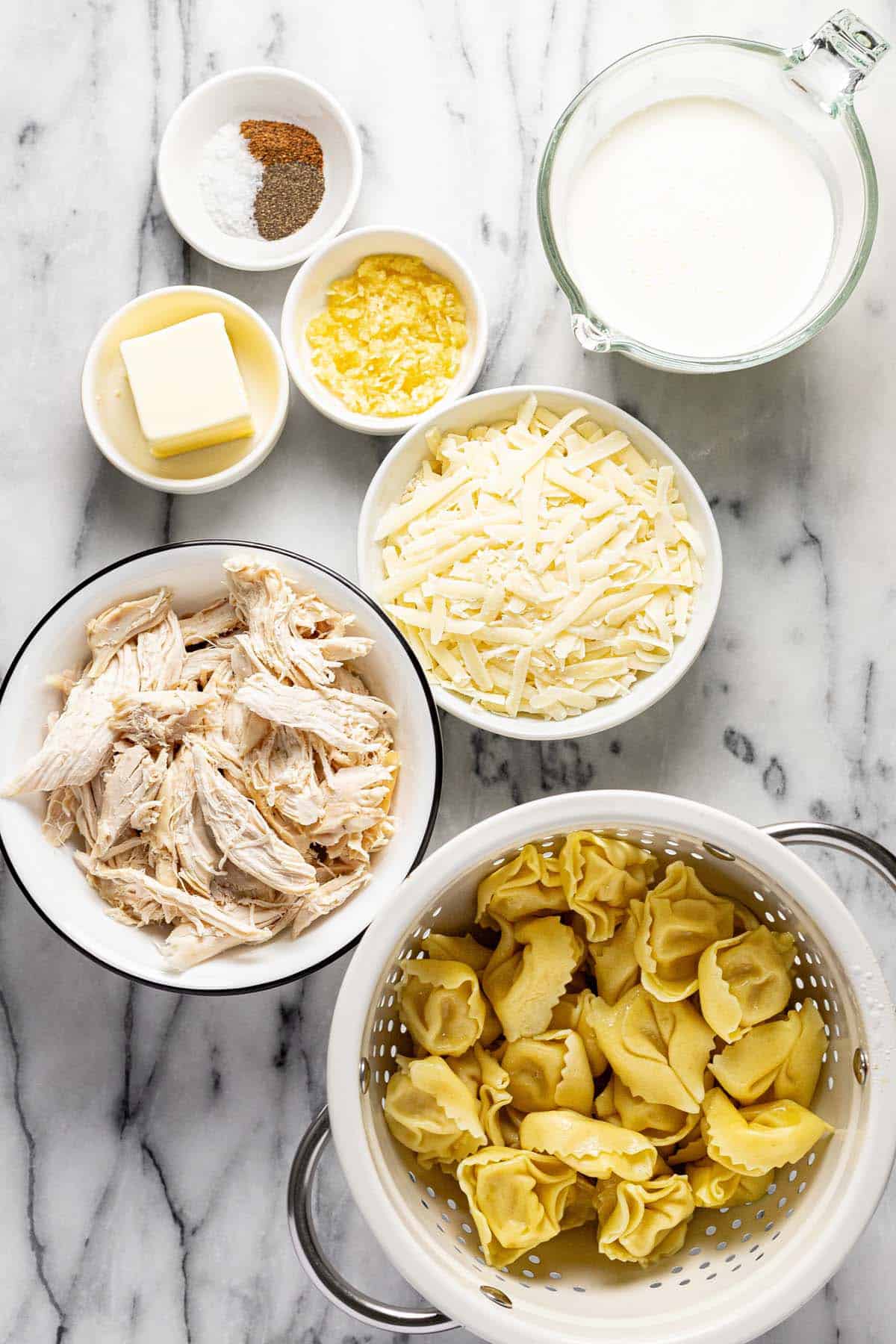 Bowls of ingredients to make chicken alfredo tortellini. 