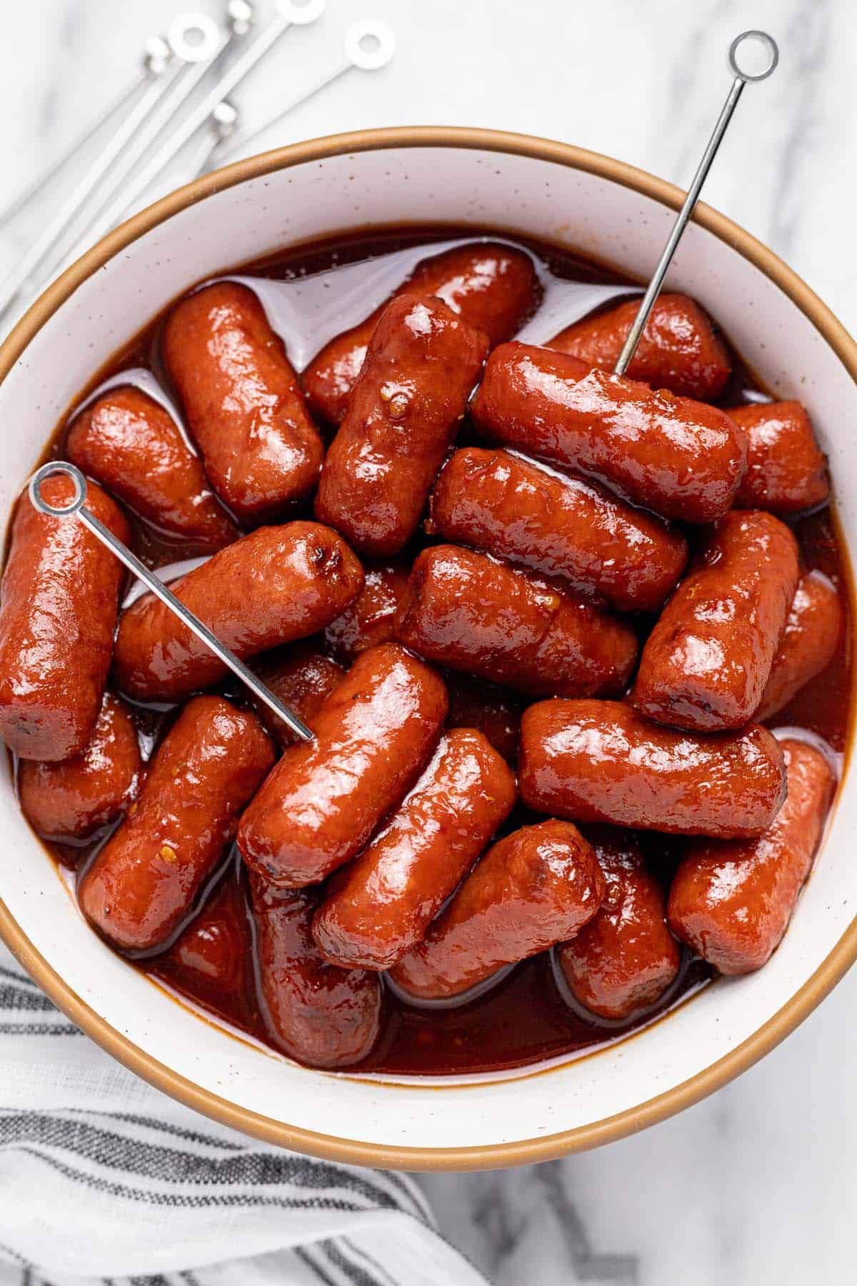 Bowl of cocktail weiners with a couple toothpicks. 