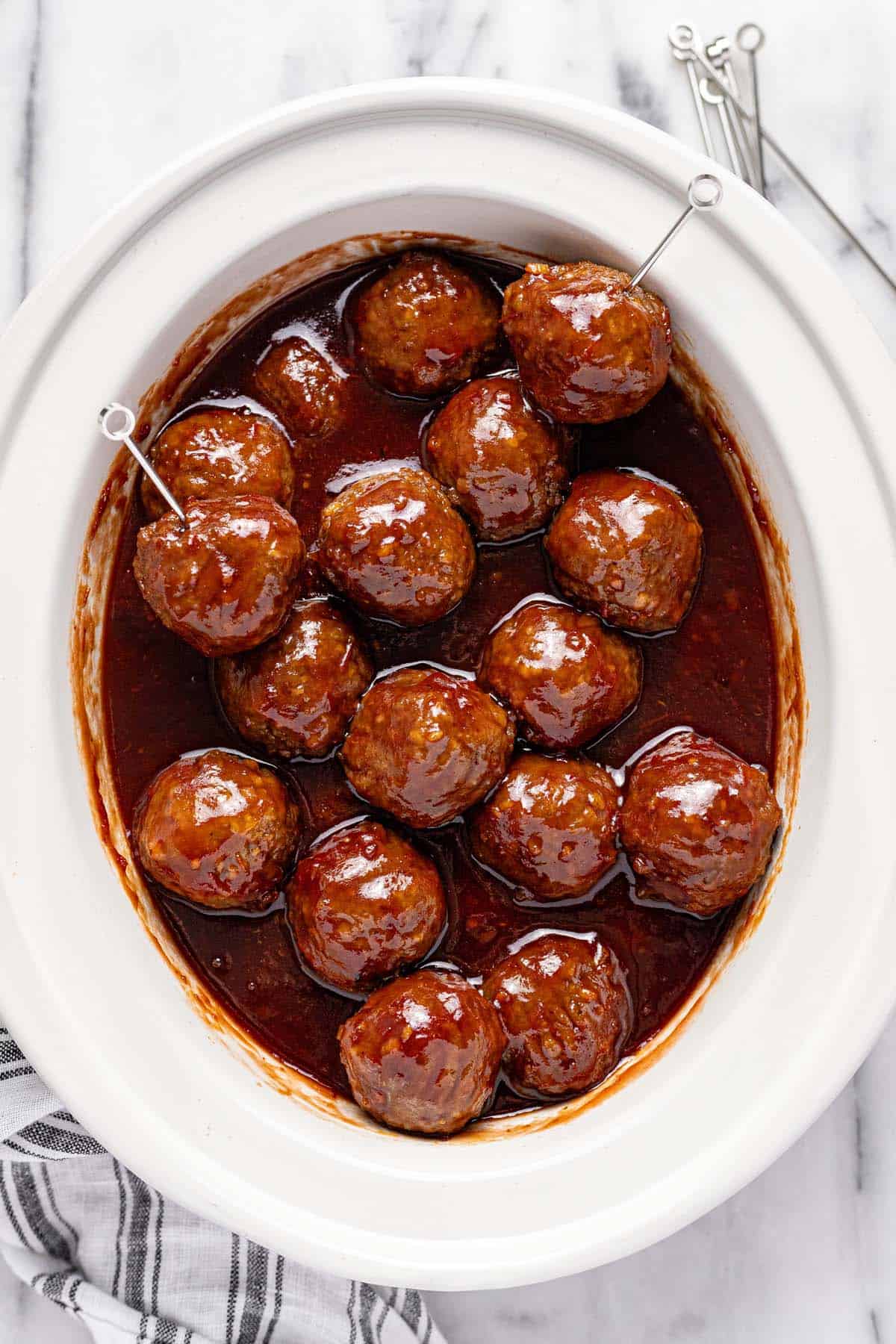 Slow cooker insert filled with cocktail meatballs. 