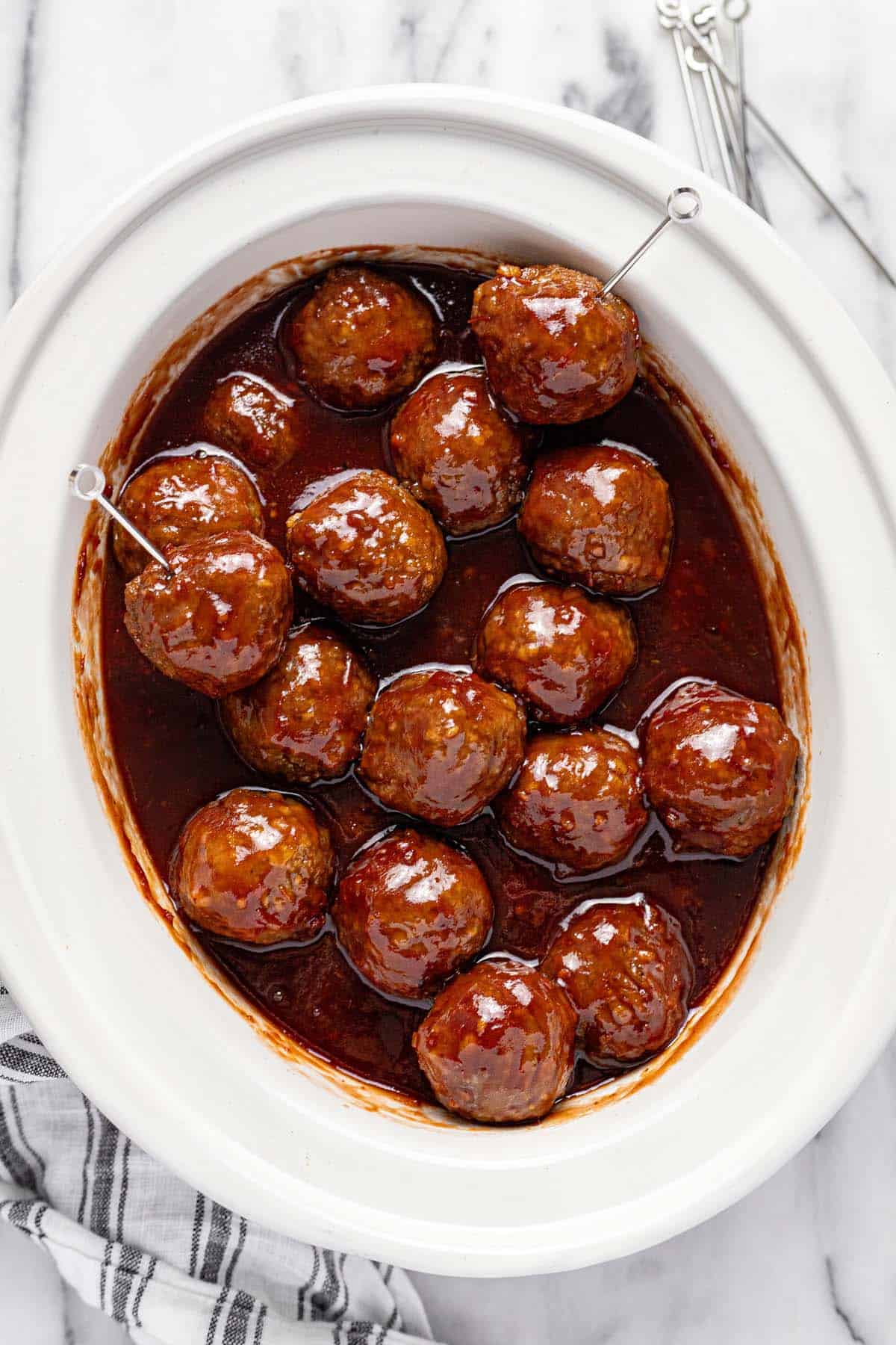 Slow cooker insert filled with cocktail meatballs. 