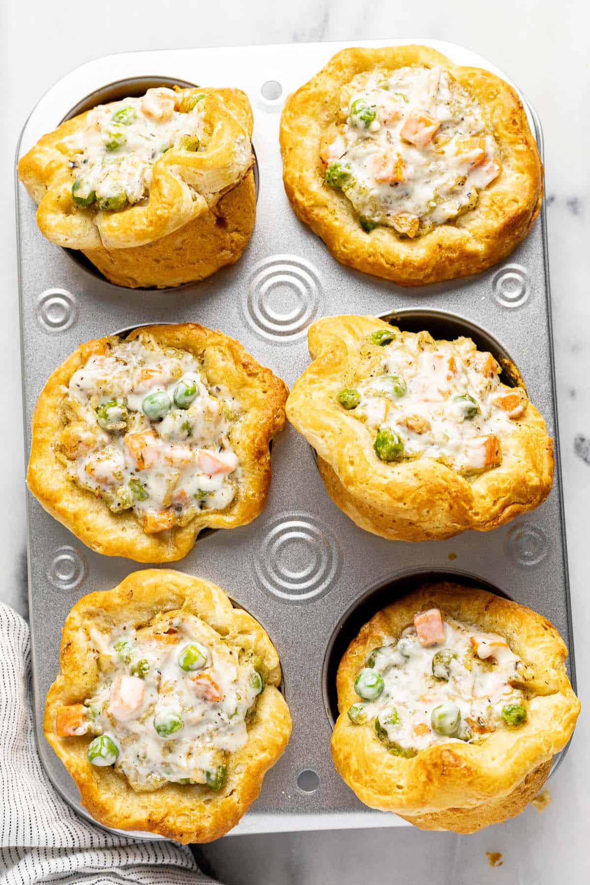 Muffin tin filled with freshly baked mini pot pies. 