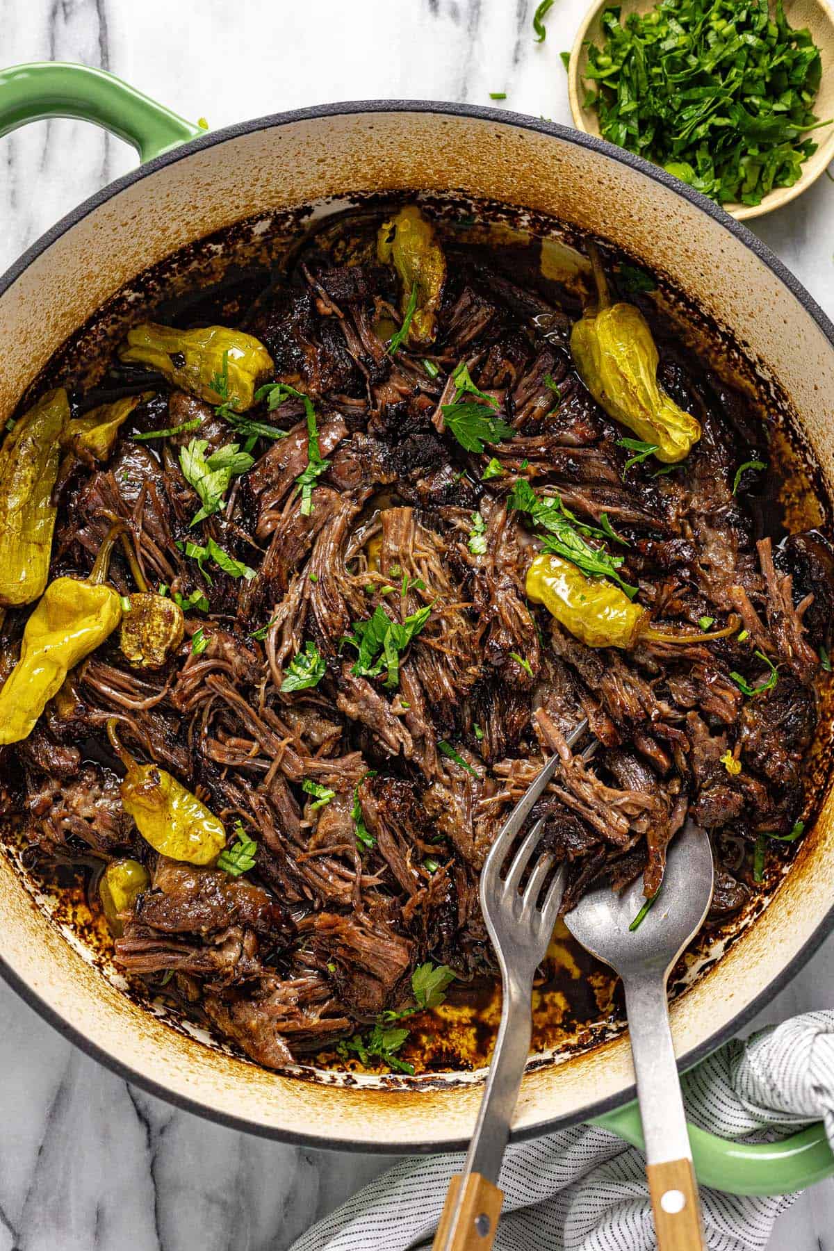 Pan filled with shredded pot roast and pepperoncini. 